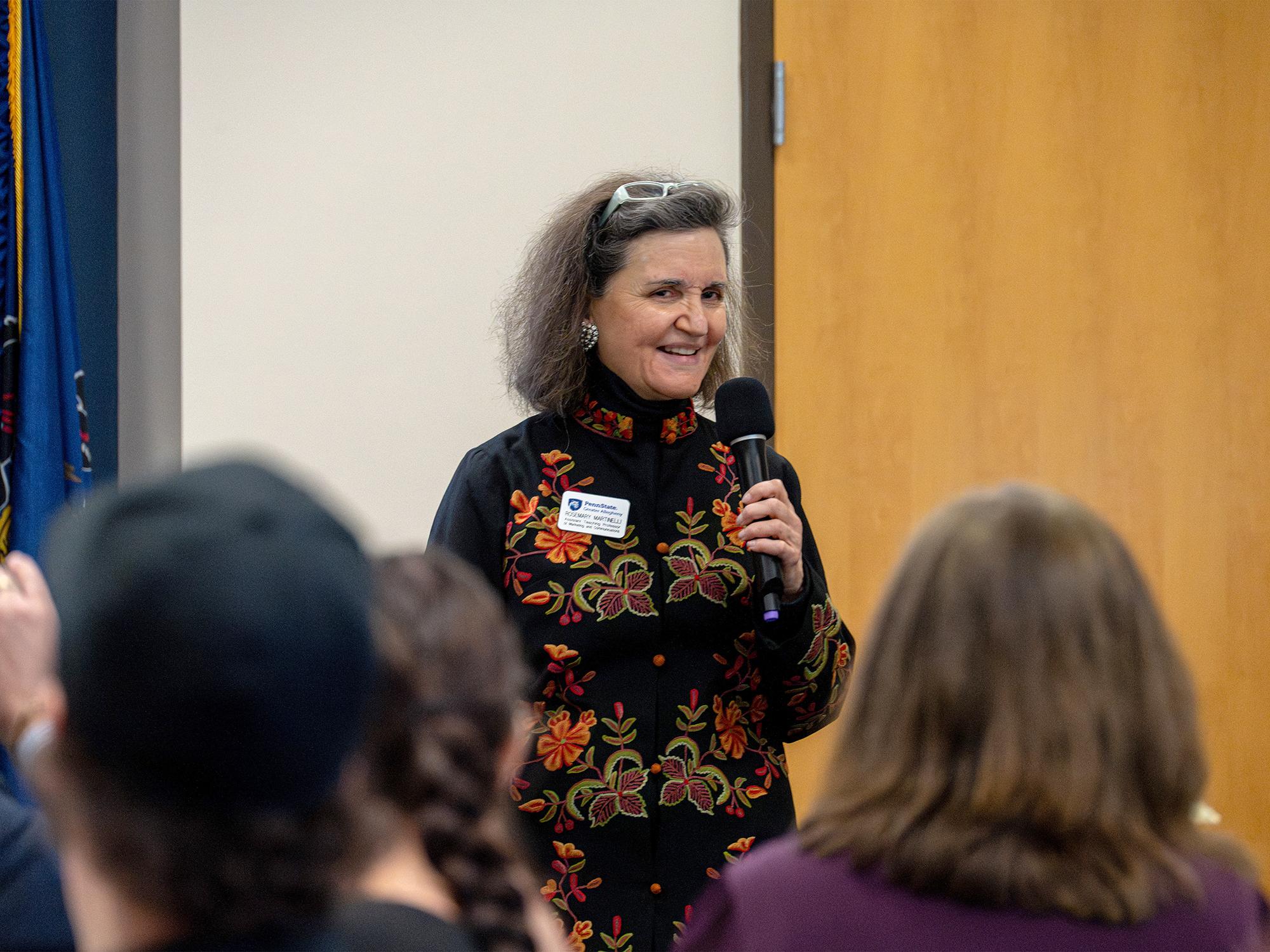 A person speaks at a podium in front of an audience