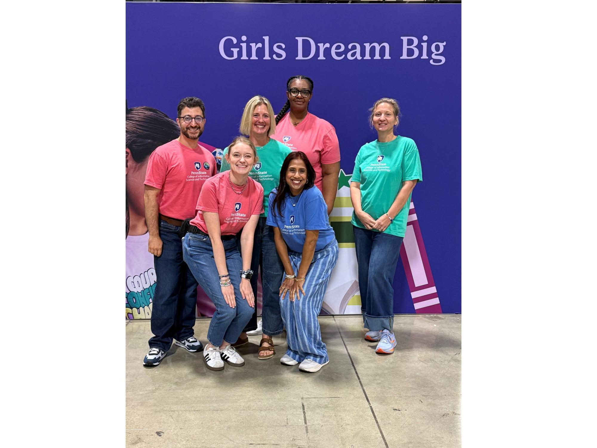 group of people in colorful t-shirts poses at convention