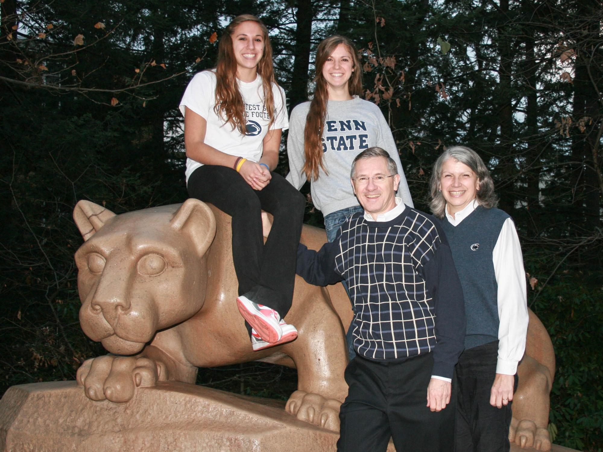 Two young girls and two parents pose at the Lion Shrine