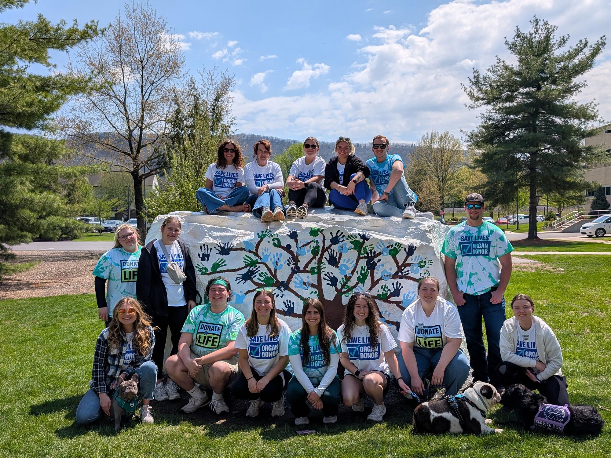 A large group of students gather for a photo outside