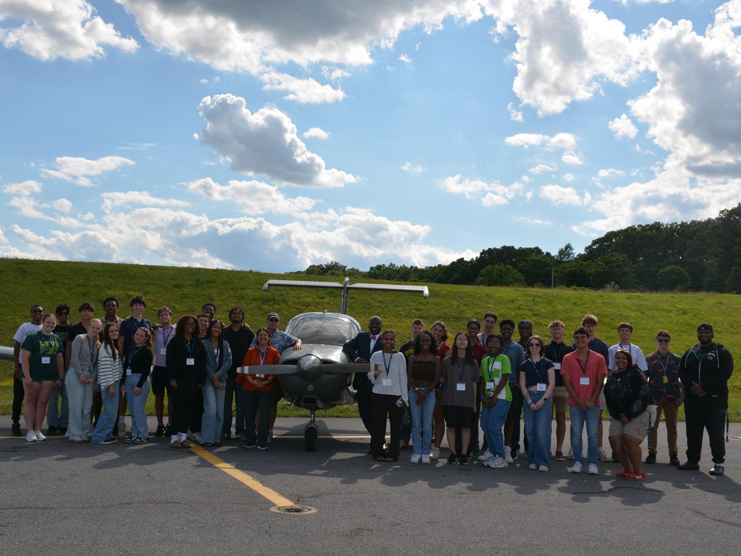 The 2026 BOSS cohort poses with airport personnel around a plane at the State College Regional Airport.