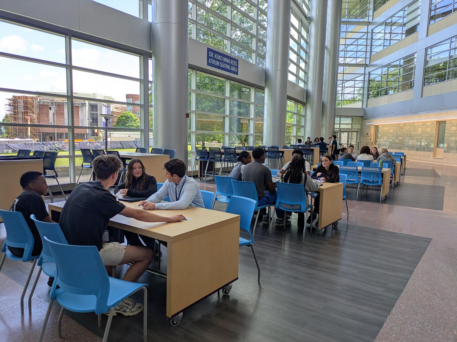 The 2026 BOSS students take a break in the Dr. Keiko Miwa Ross Atrium of the Business Building.