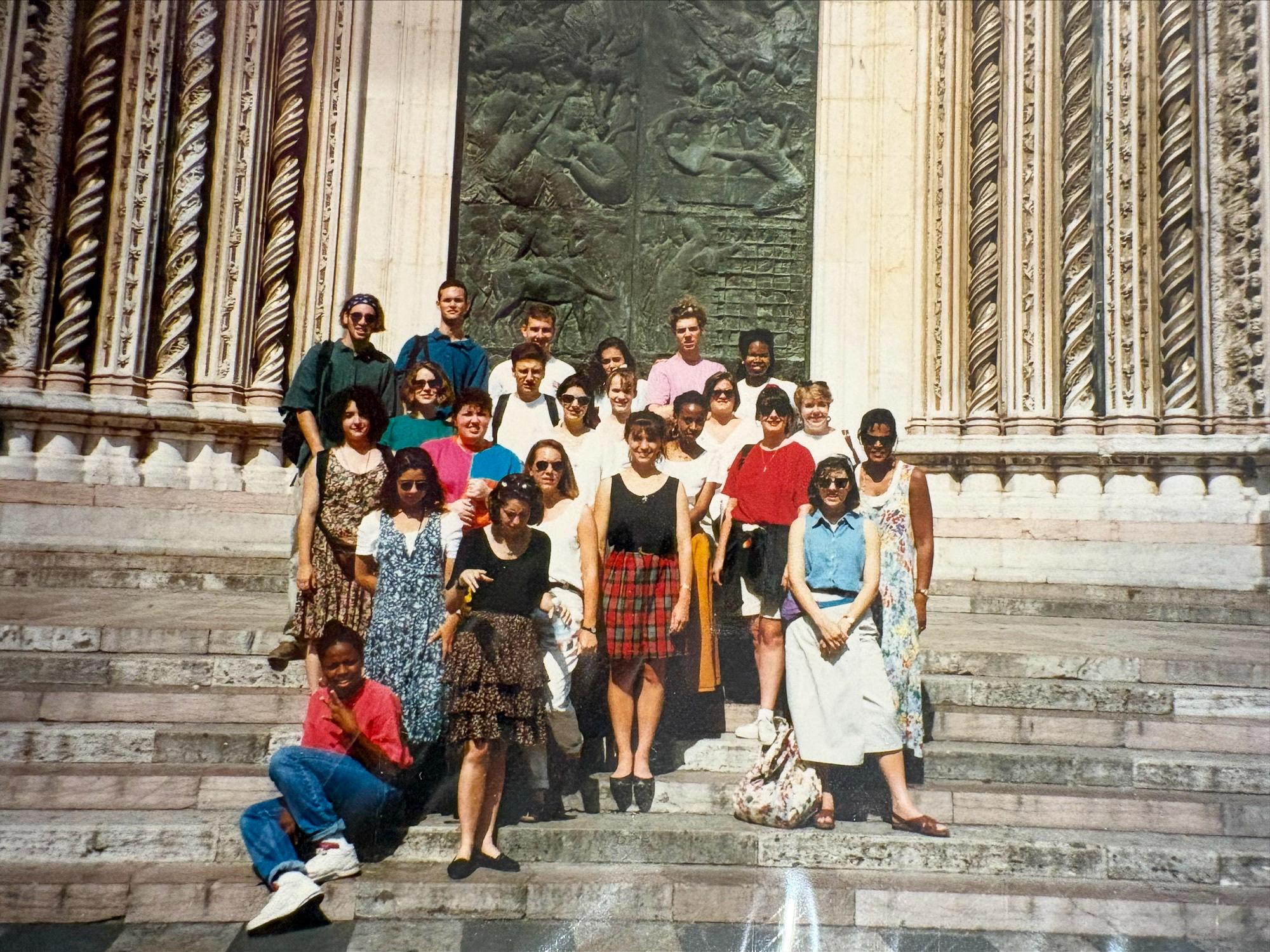 A group of people in 1993, stand before a building in Italy.