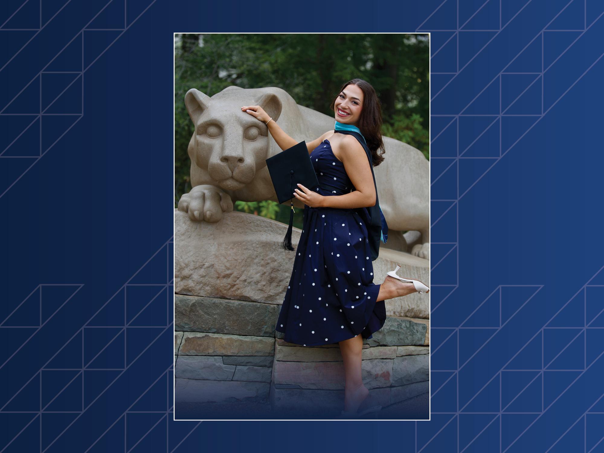 A woman poses in front of the Nittany Lion Shrine.