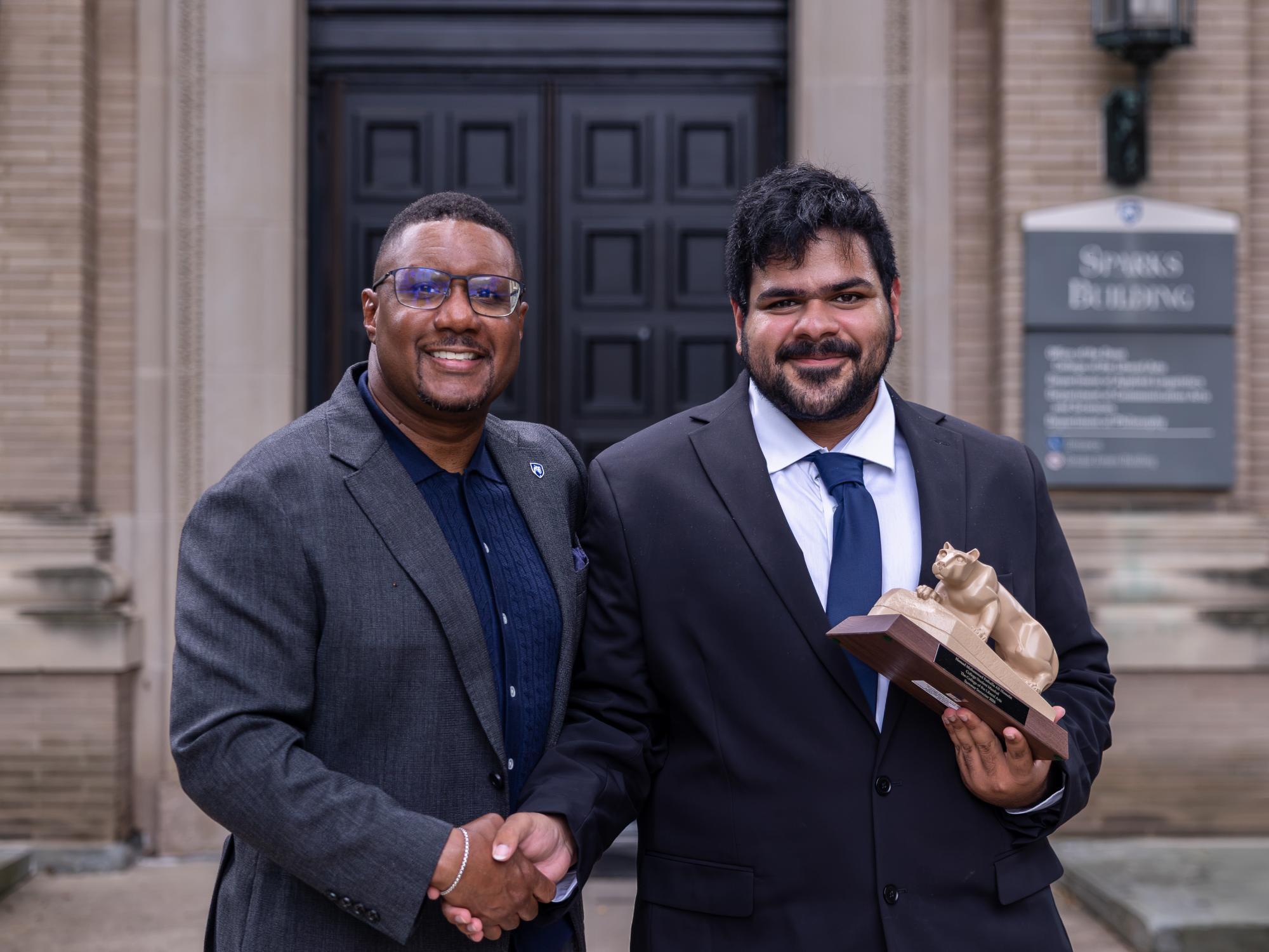 : Hamad Hussain shakes hands with Dean Clarence Lang outside Sparks Building.