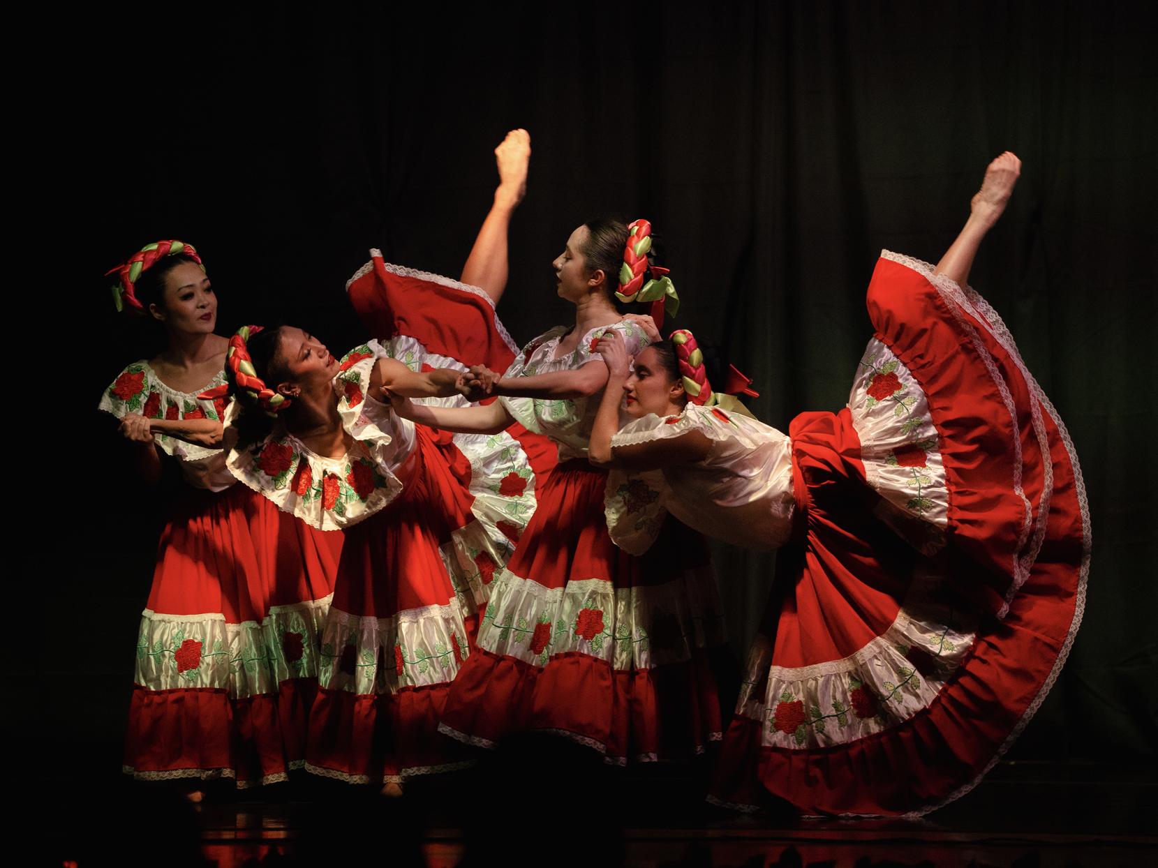 Ballerinas dance in colorful red and white dresses 