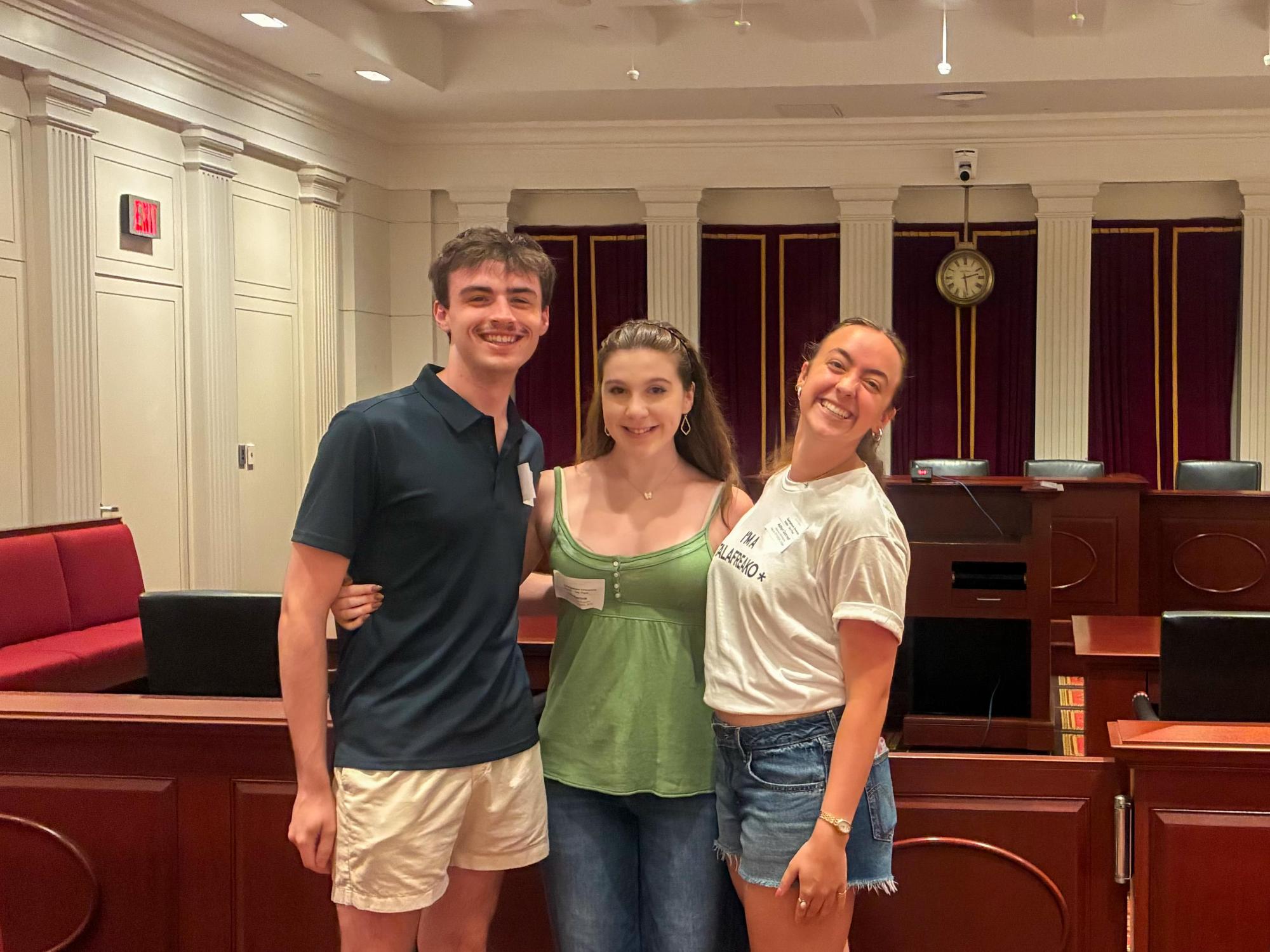 Ella Bartnik wears a green top and blue jeans while standing in Georgetown Law School. 
