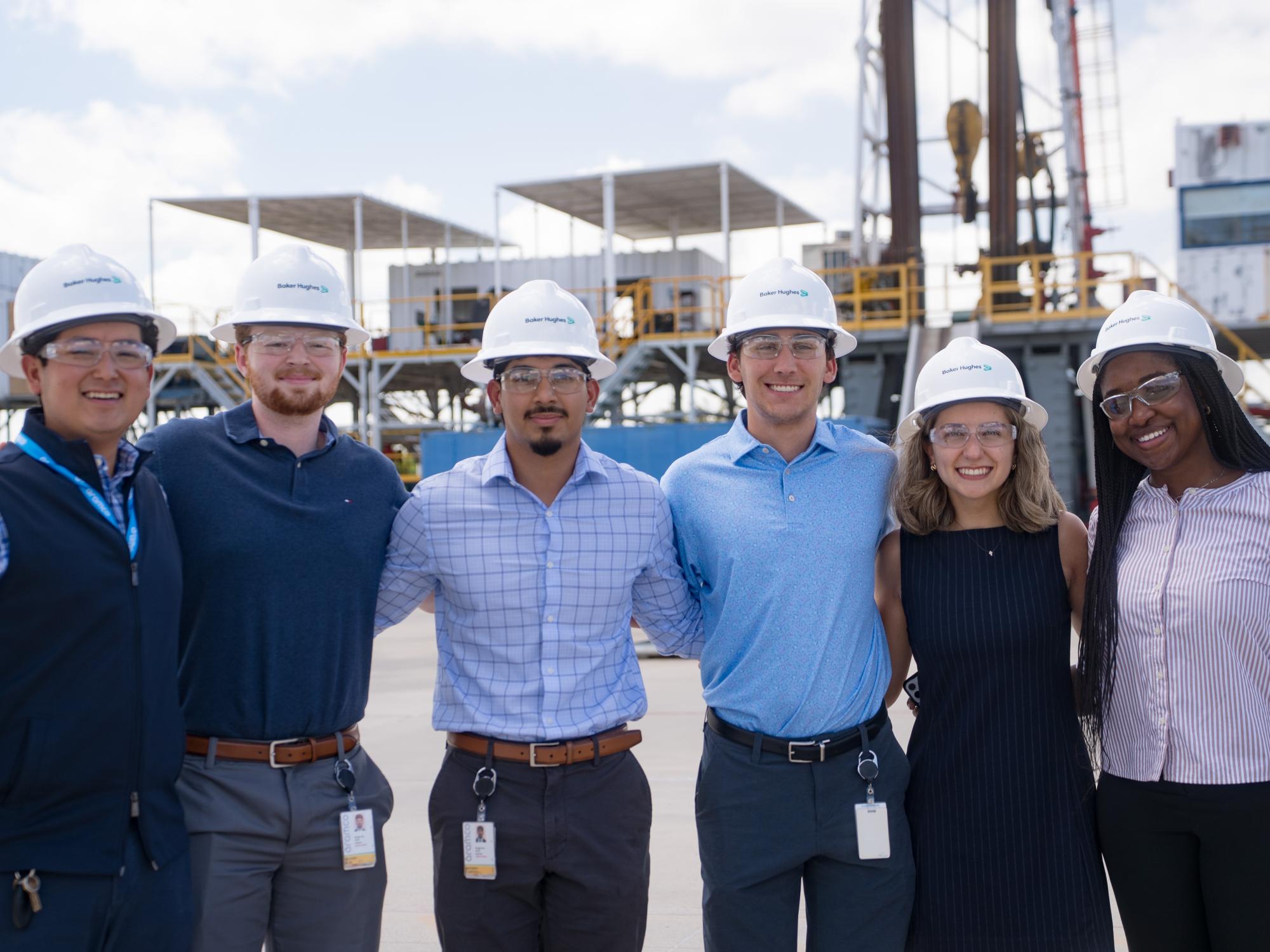 Osakiodeme Ikhinmwin stands with five other interns while wearing hardhats outdoors. 