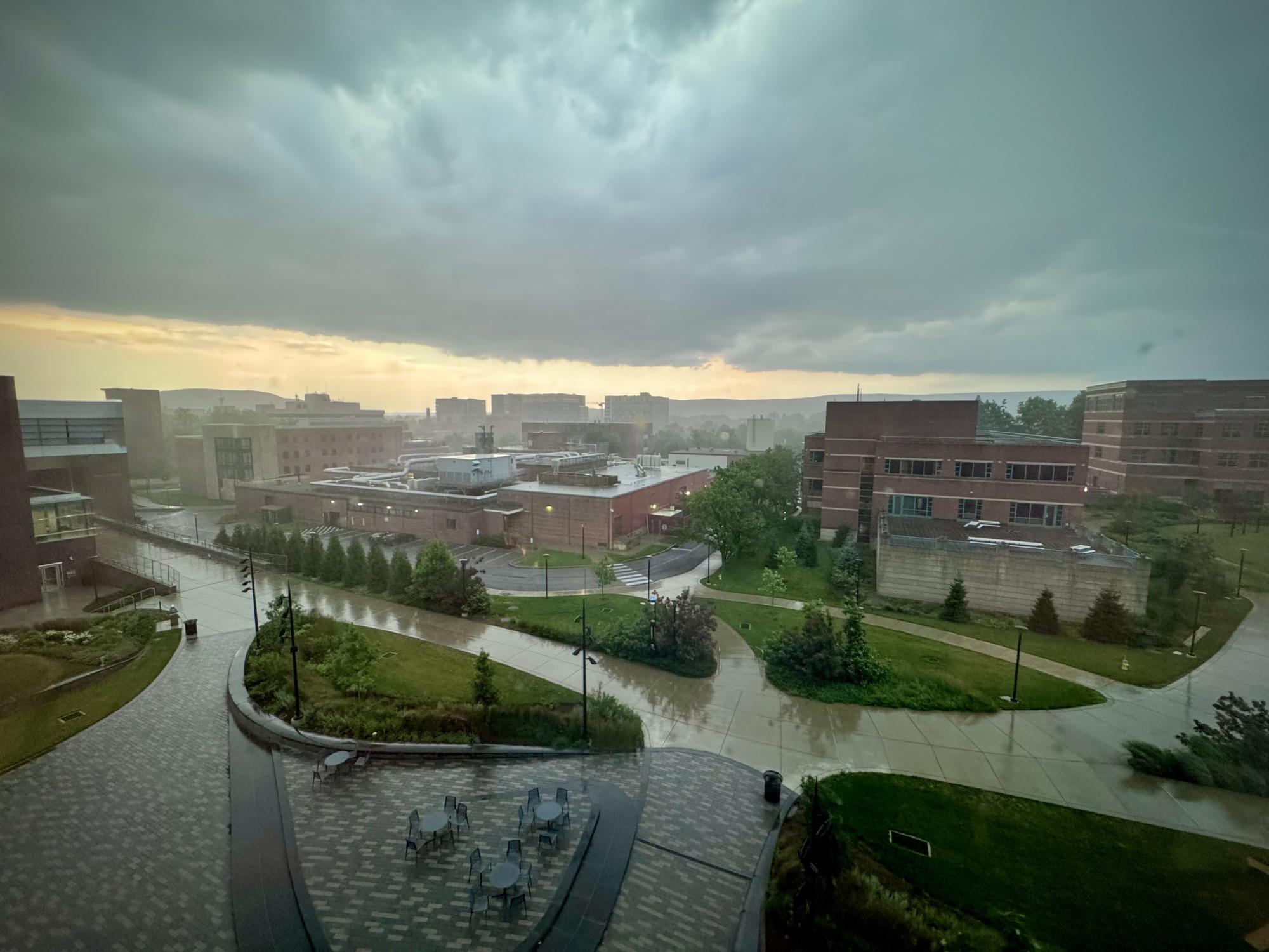 A wide shot of part of a college campus under dark storm clouds