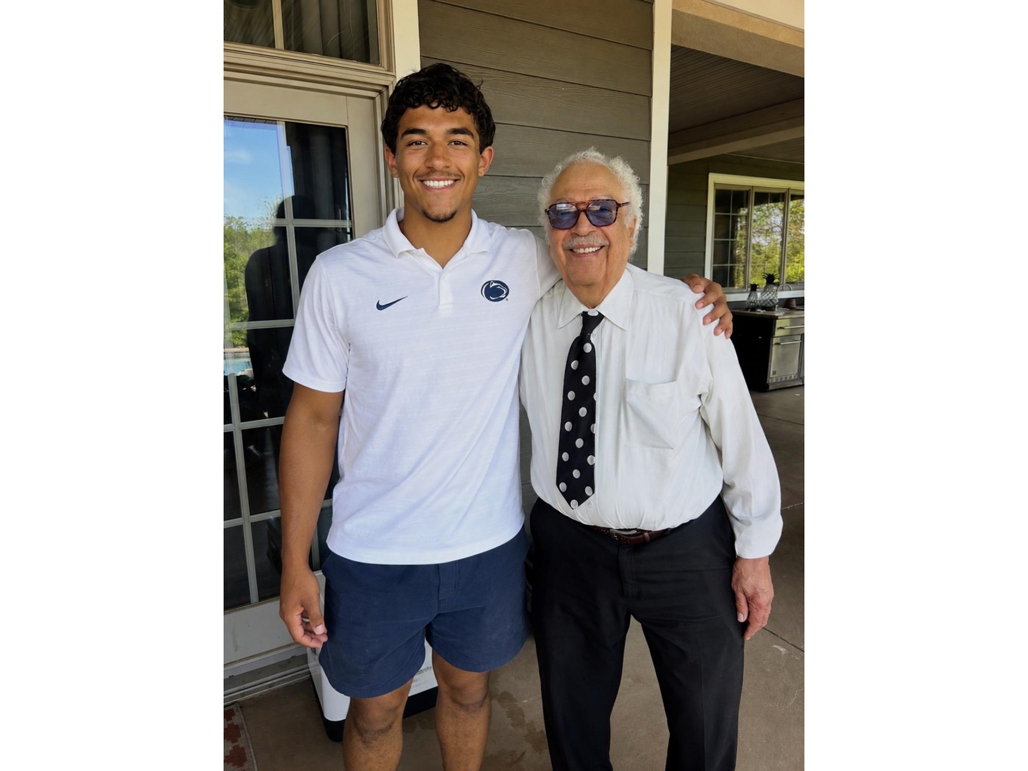 John and Wes Robinson smiling with their arms around each other at the Robinson family home
