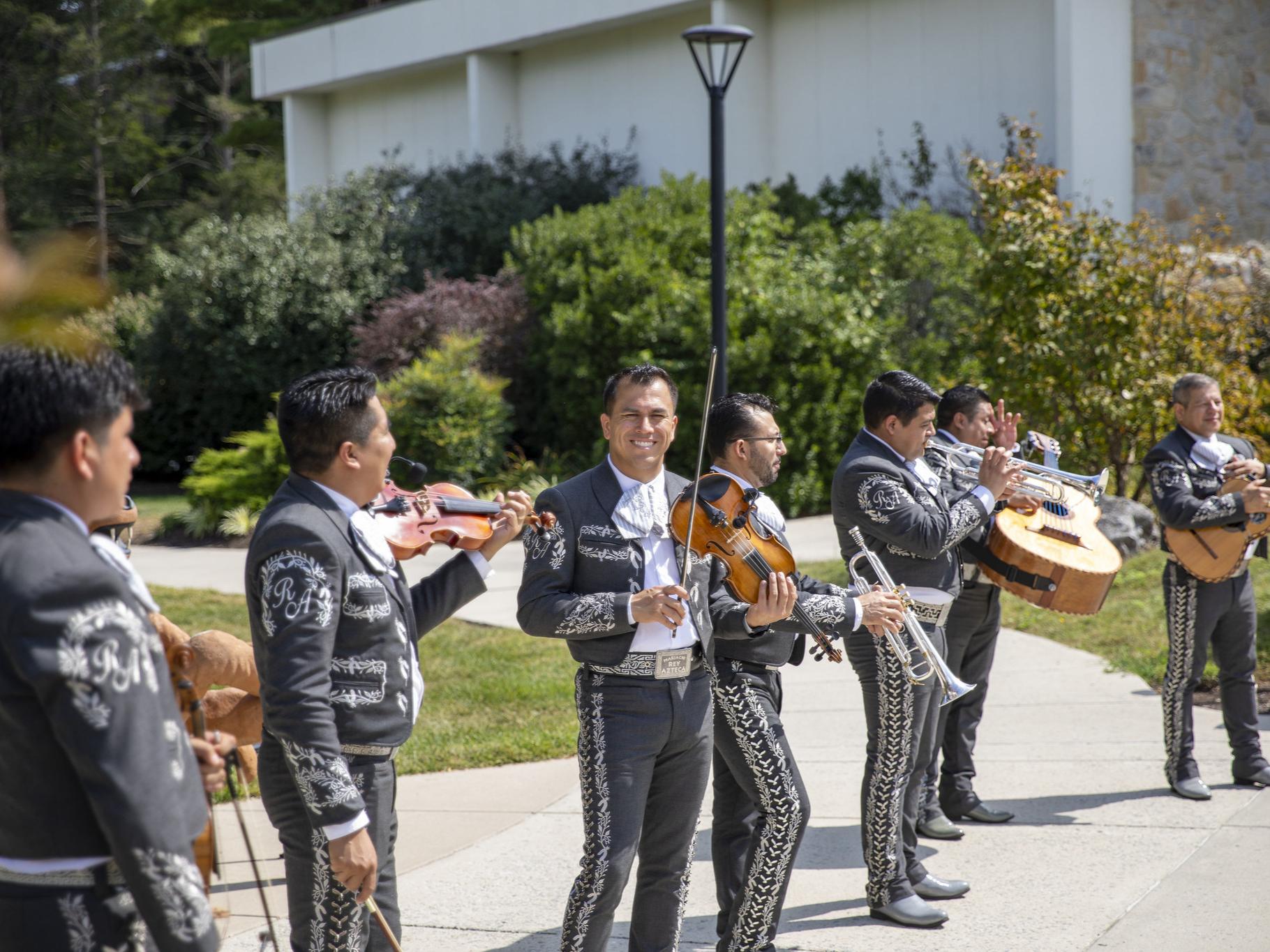 A mariachi band is playing outside the Perkins Student Center.