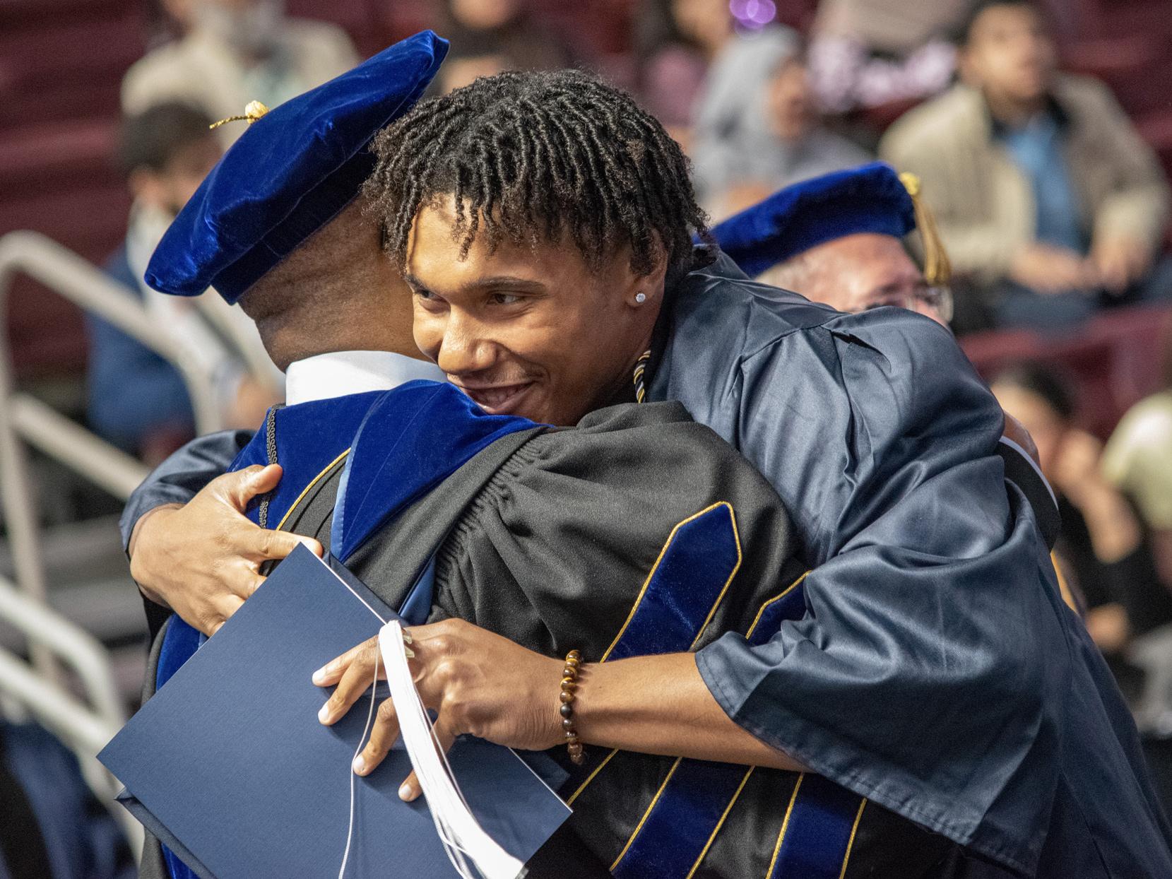Roderick Lee hugs a student at graduation