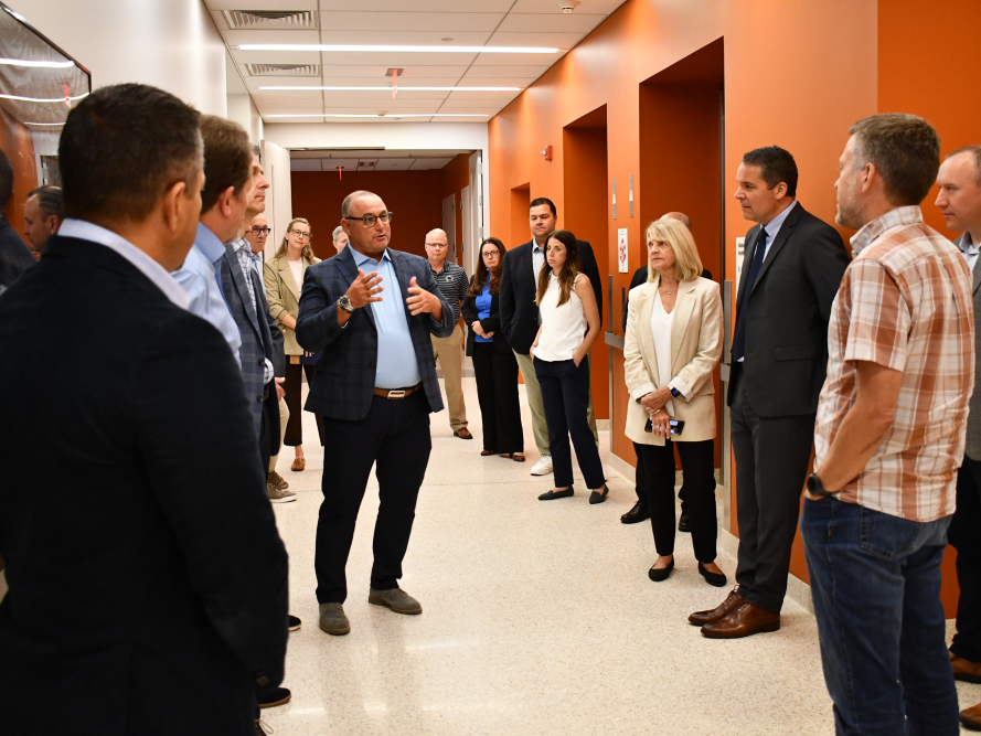 man talking to group in hallway