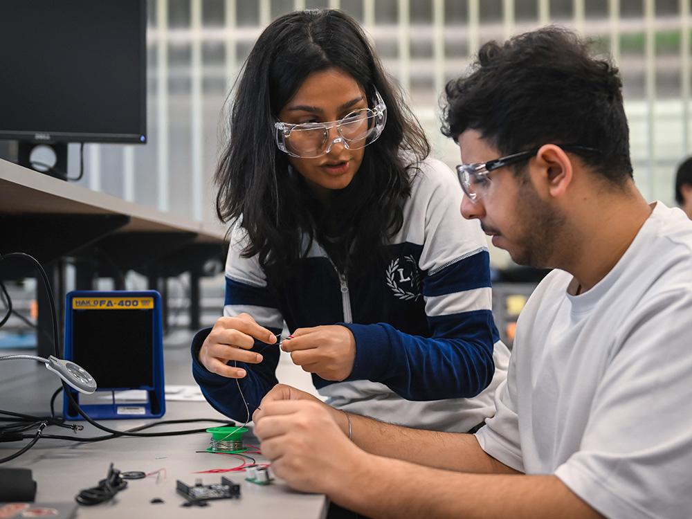 Two students work on a project in the Learning Factory. 