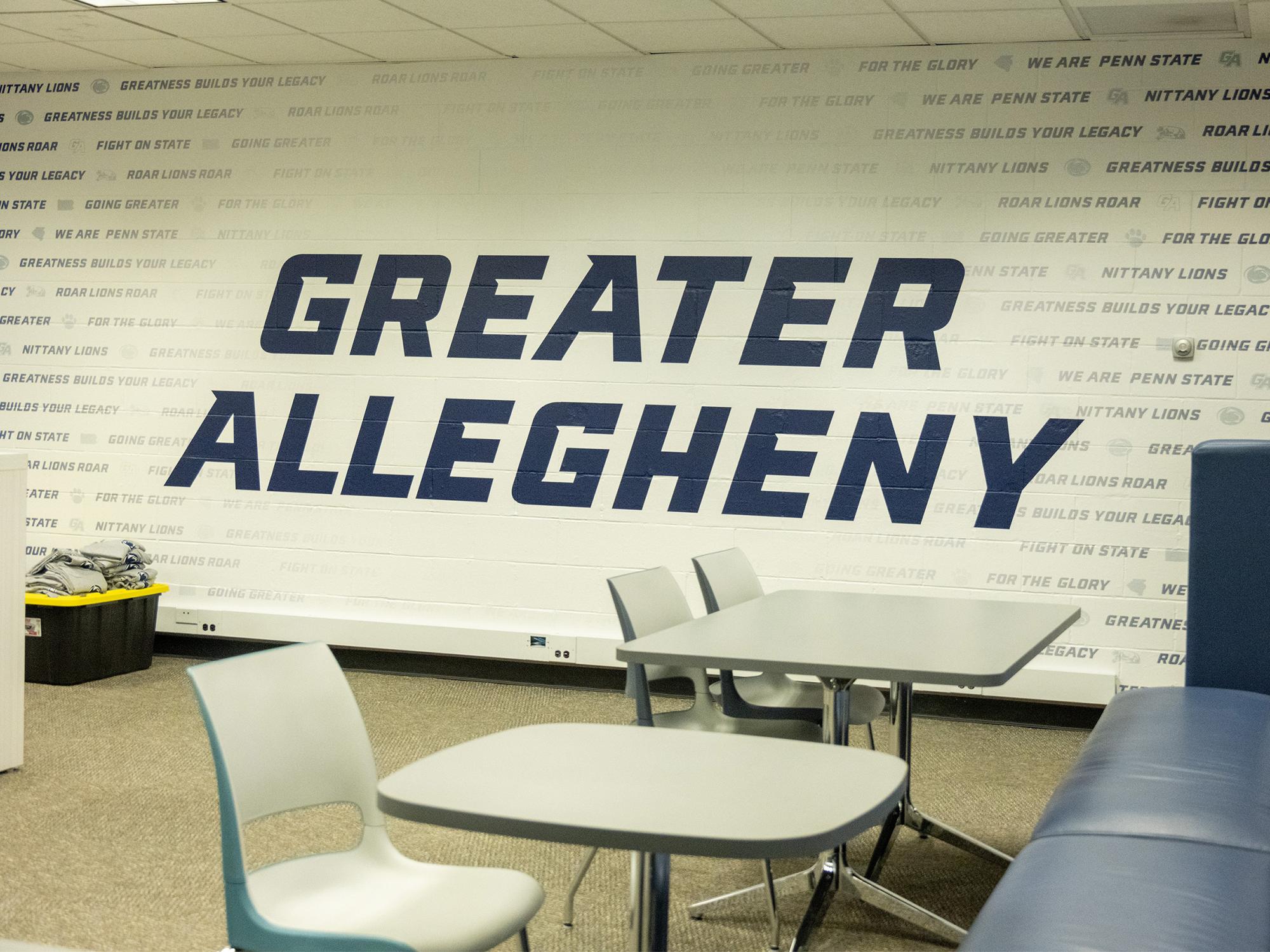 The renovated athlete lounge in Wunderley Gymnasium includes new seating, tables, and a large "Greater Allegheny" wall graphic surrounded by Penn State and athletics-themed messaging.