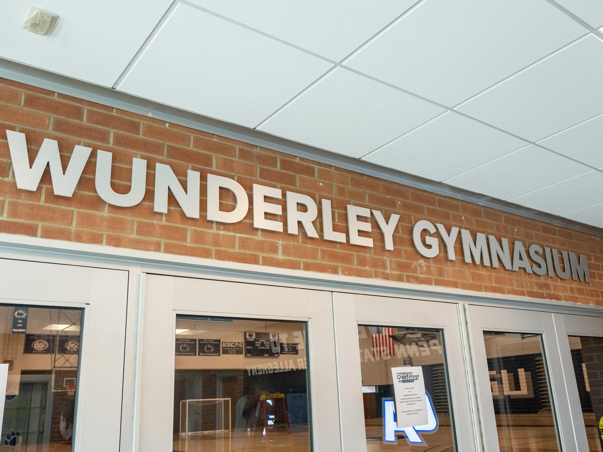 Updated “Wunderley Gymnasium” lettering is mounted above the entrance doors to the facility, with the gymnasium visible through the glass.