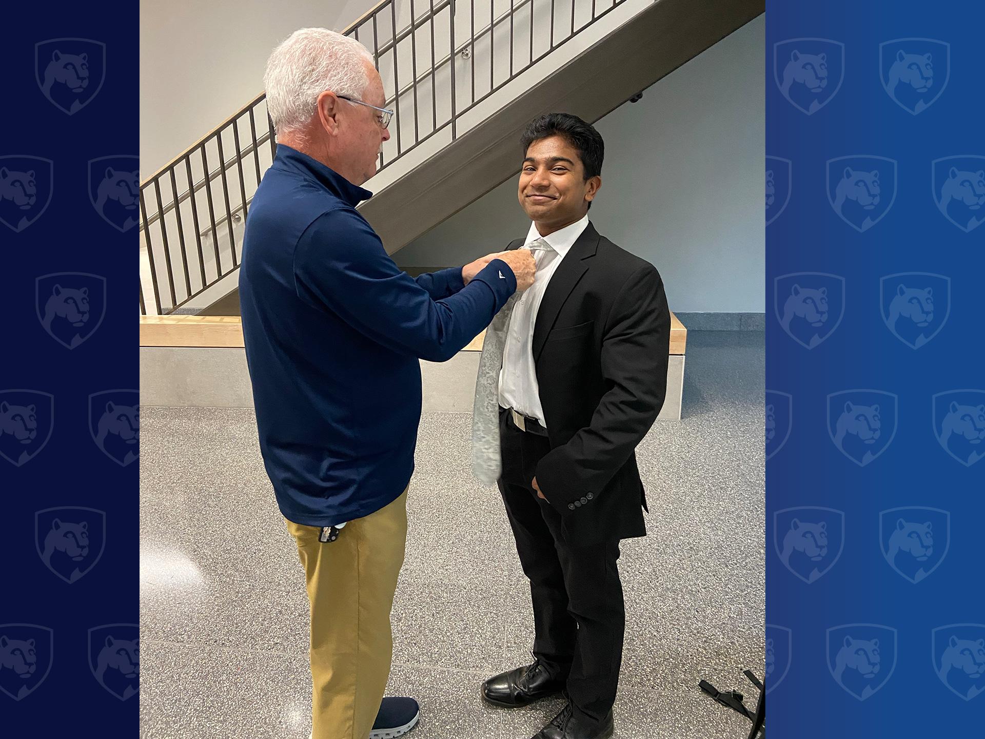 man helping man tie his tie