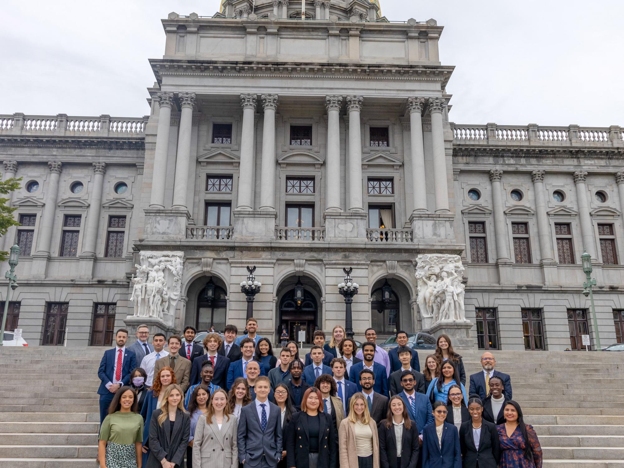 Members of the Next Gen Academy stand together in front of the dome-topped Harrisburg Capitol Building.