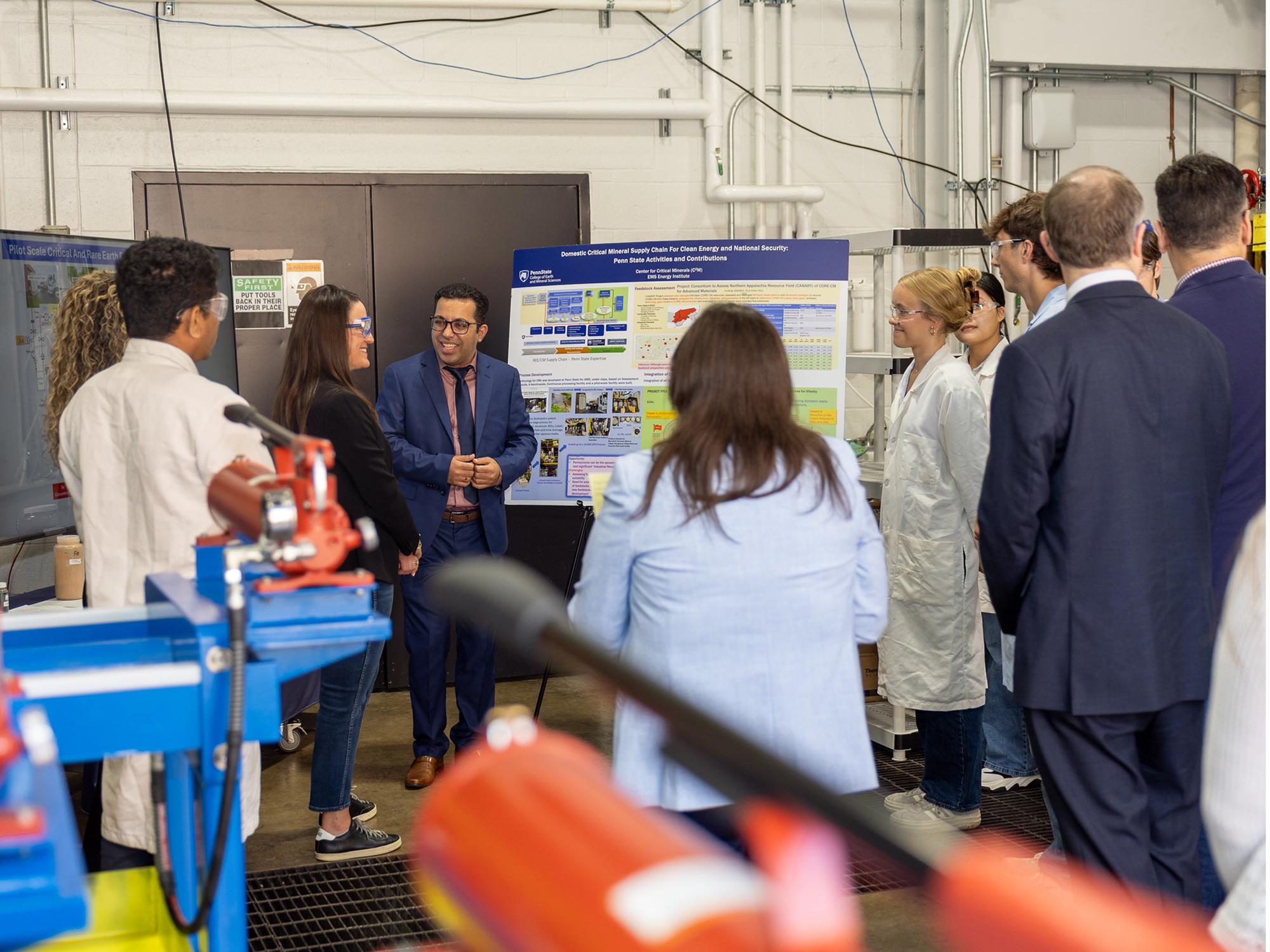 A man and a woman discuss research that's conducted in a critical minerals extraction facility