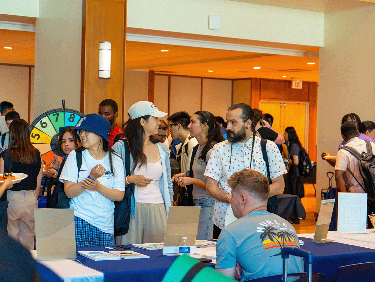 A group of graduate students connect with a University support office at the Welcome Engagement Fair for Graduate Students.