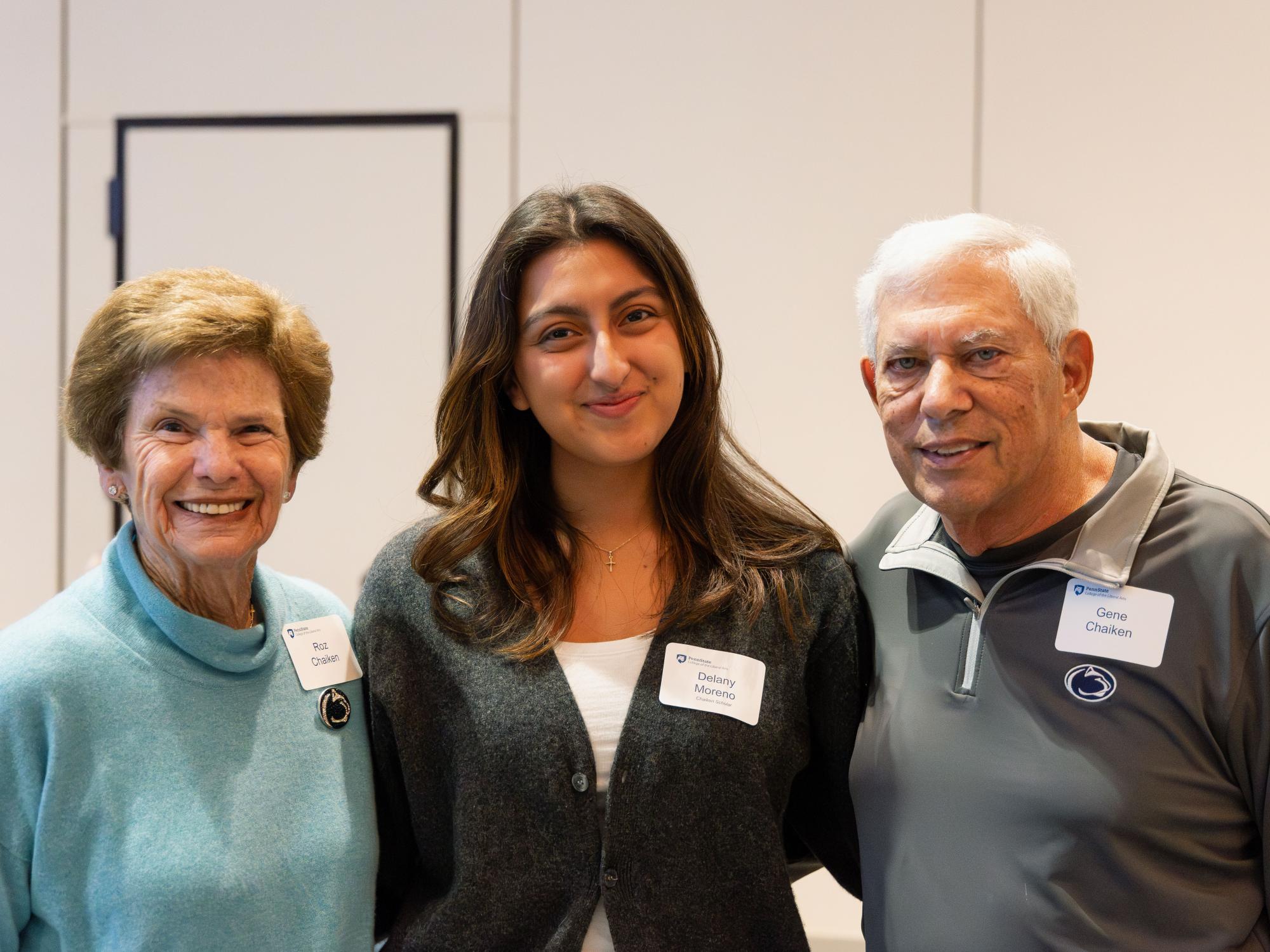 Delany Moreno stands between Roz and Gene Chaiken while all three smile at the camera.