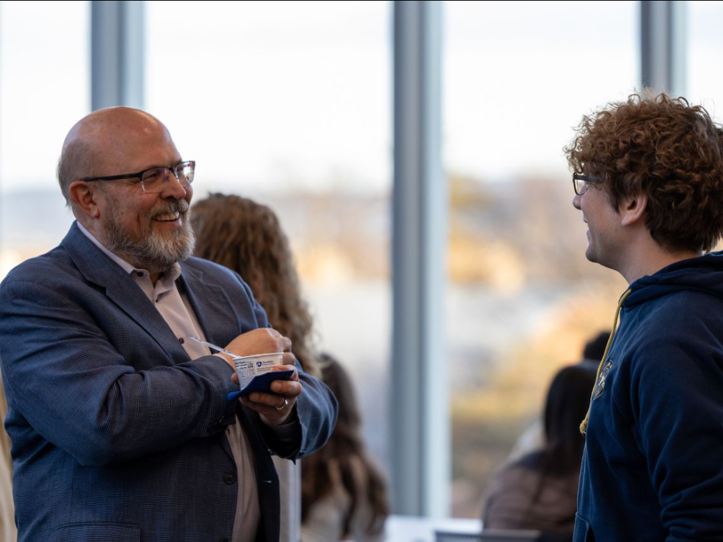 Lilliard Richardson speaks with a student at a School of Public Policy event. 