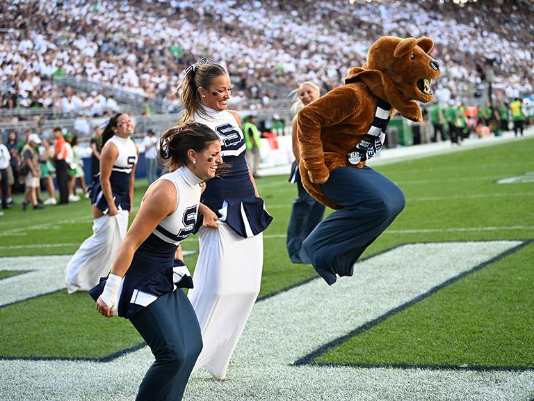 Mascot and cheerleaders in potato sack race