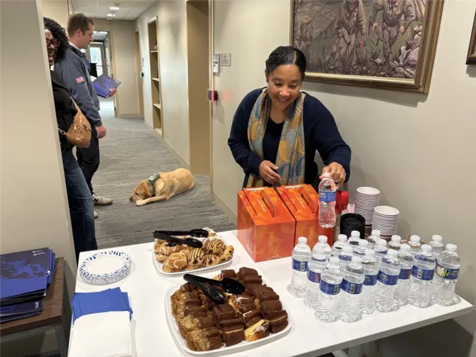 A person serves snacks and drinks from a table