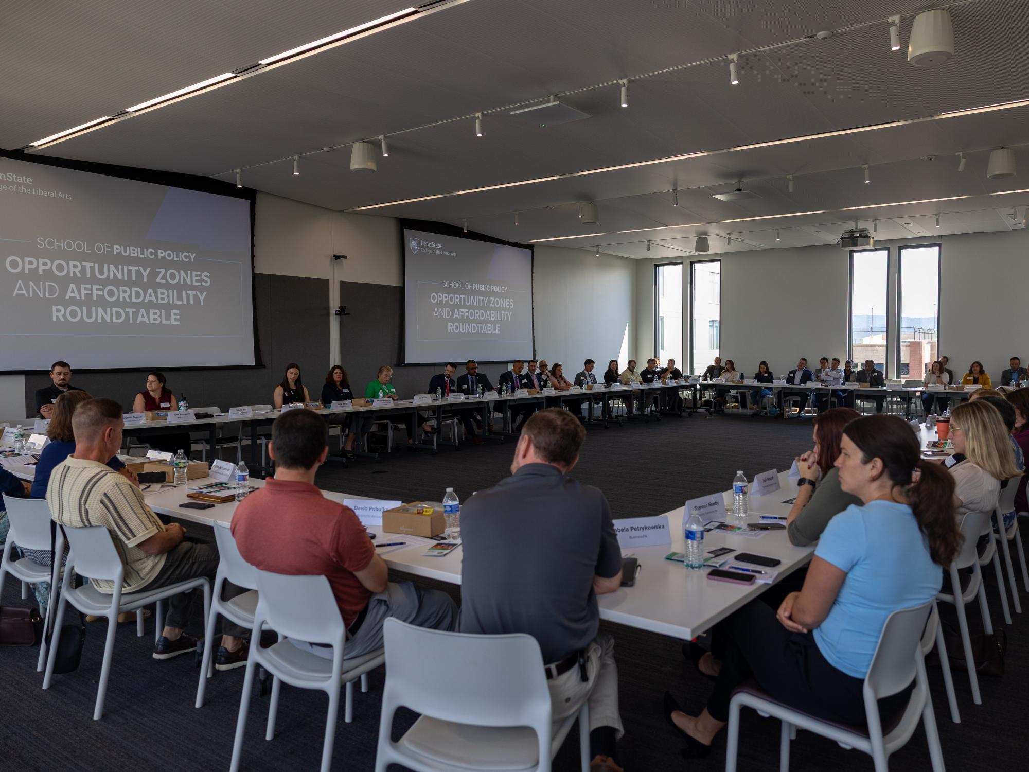 A large room filled with meeting attendees seated at tables