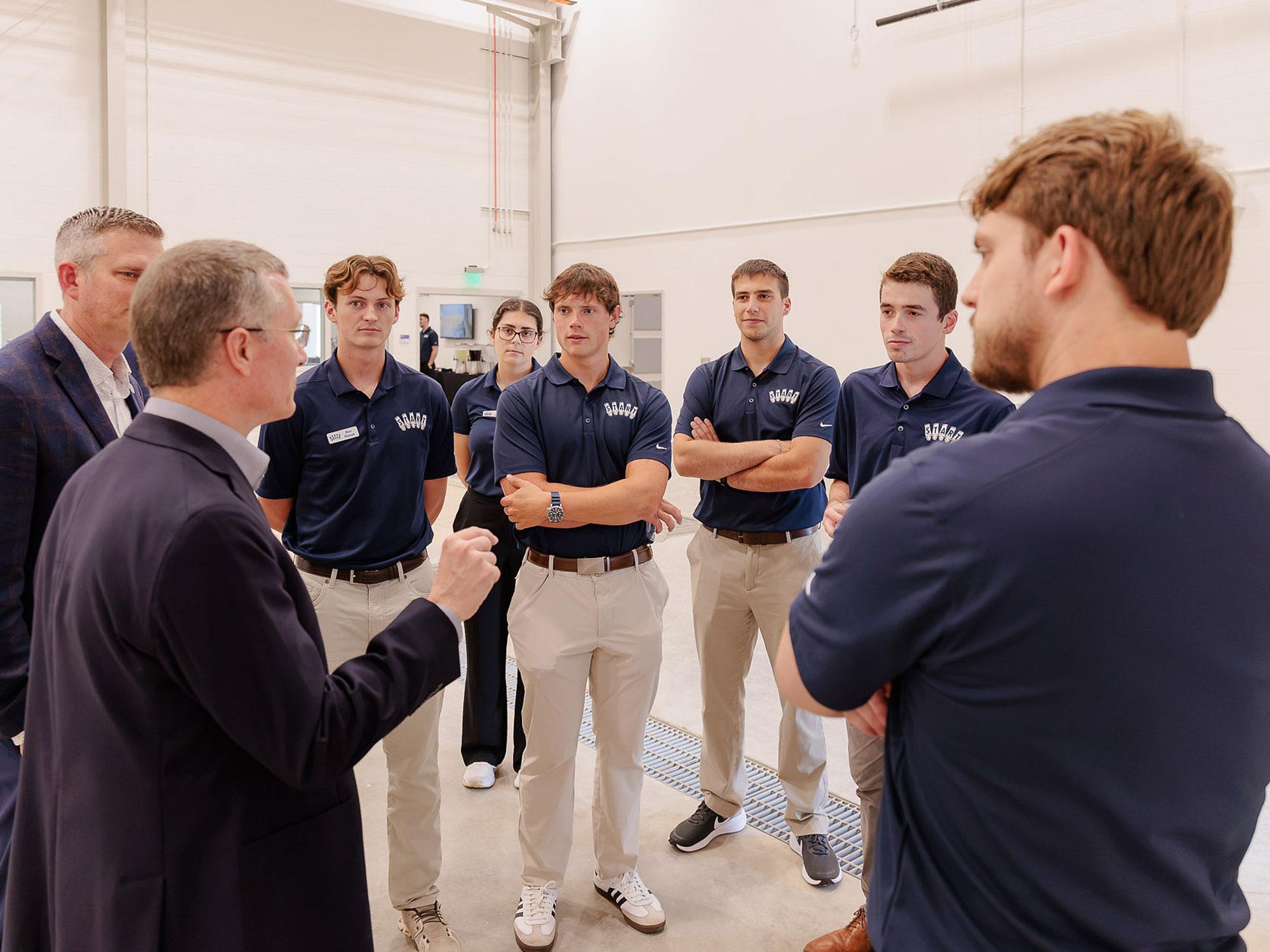 Two industry representatives speak with grad students at the START+ lab ribbon cutting