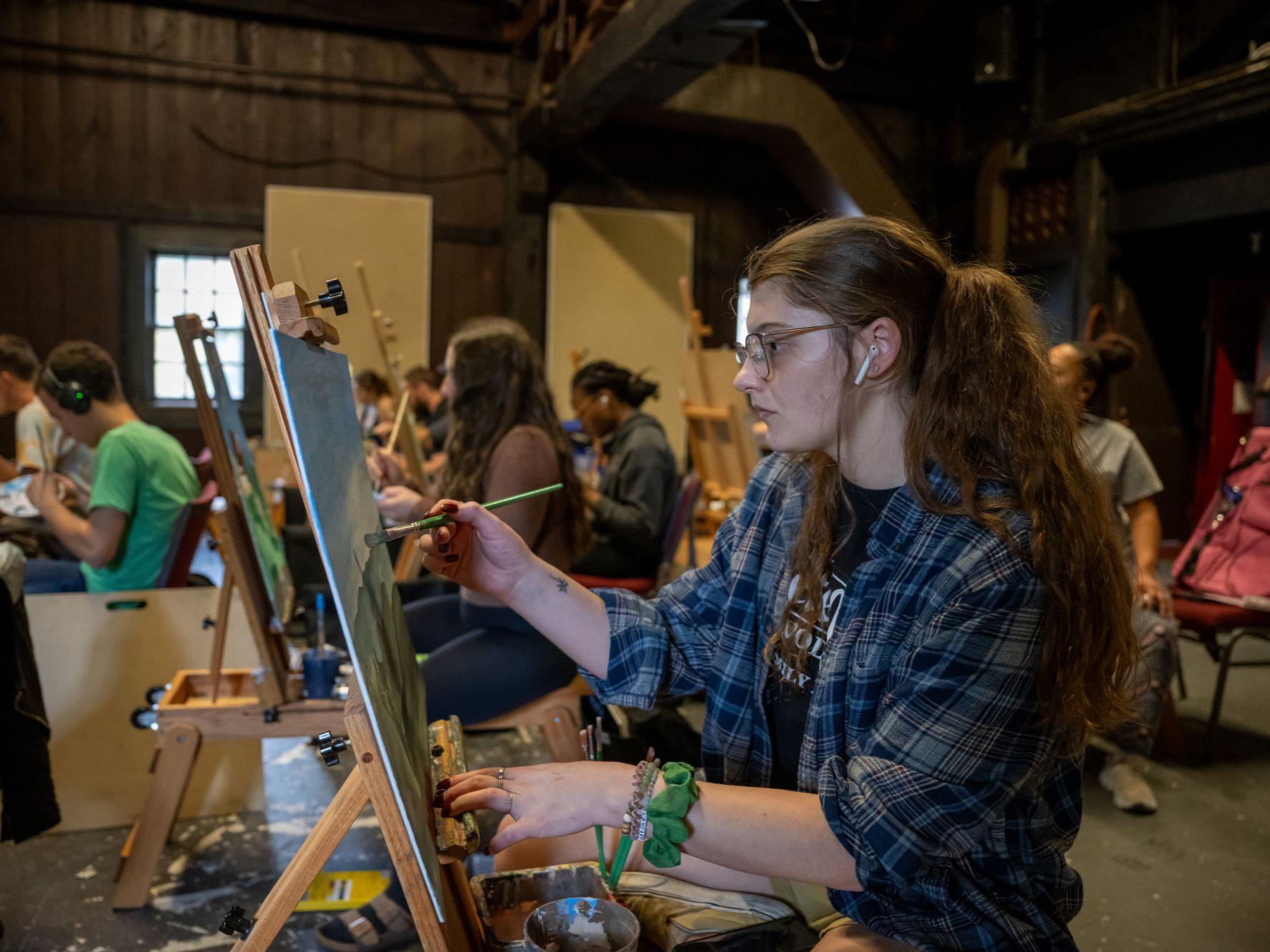 A student paints in an art class in the Mary Behrend Studio.