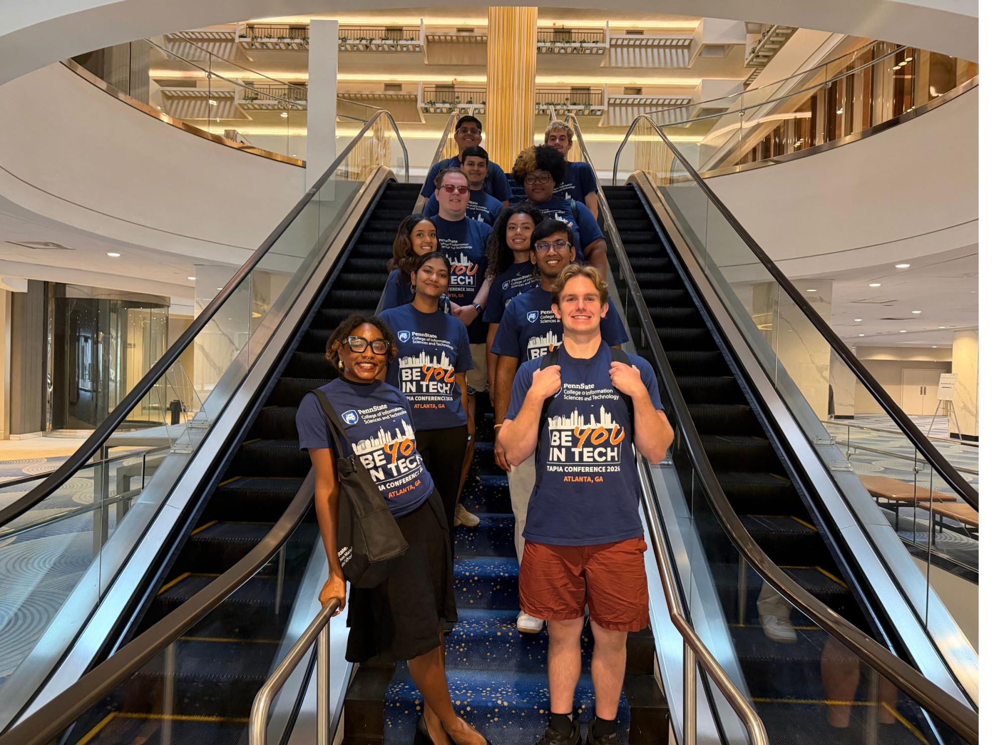 college students wearing matching t-shirts on hotel escalator