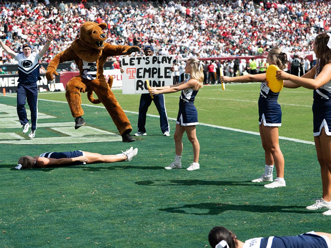 Lion jumps over cheerleader