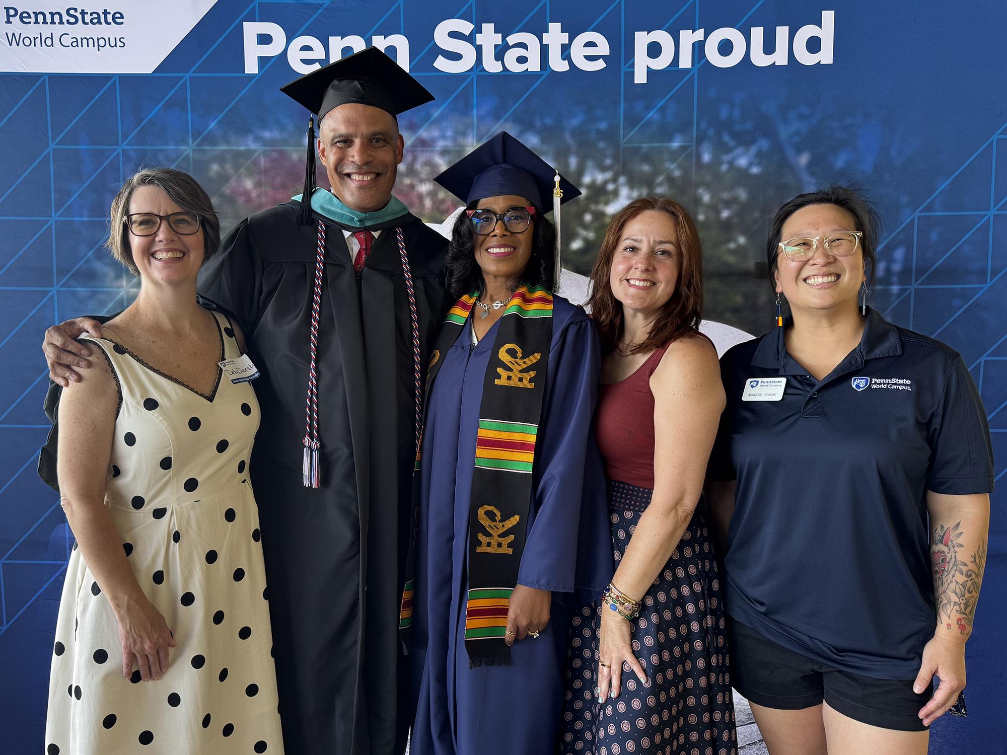 Five people pose in front of a Penn State photo background.