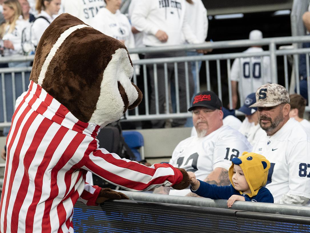 Badger mascot fist bumps child