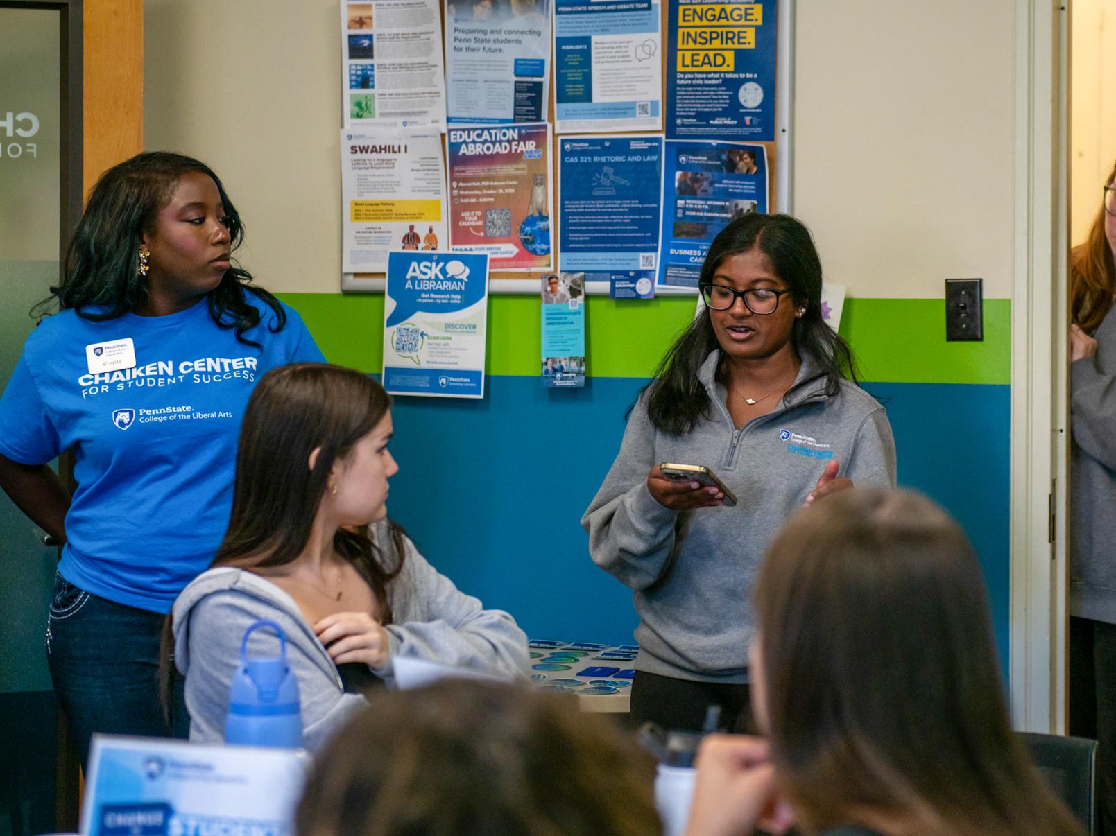Alyssa Nigel reads off her phone while speaking to a group of students during an event.