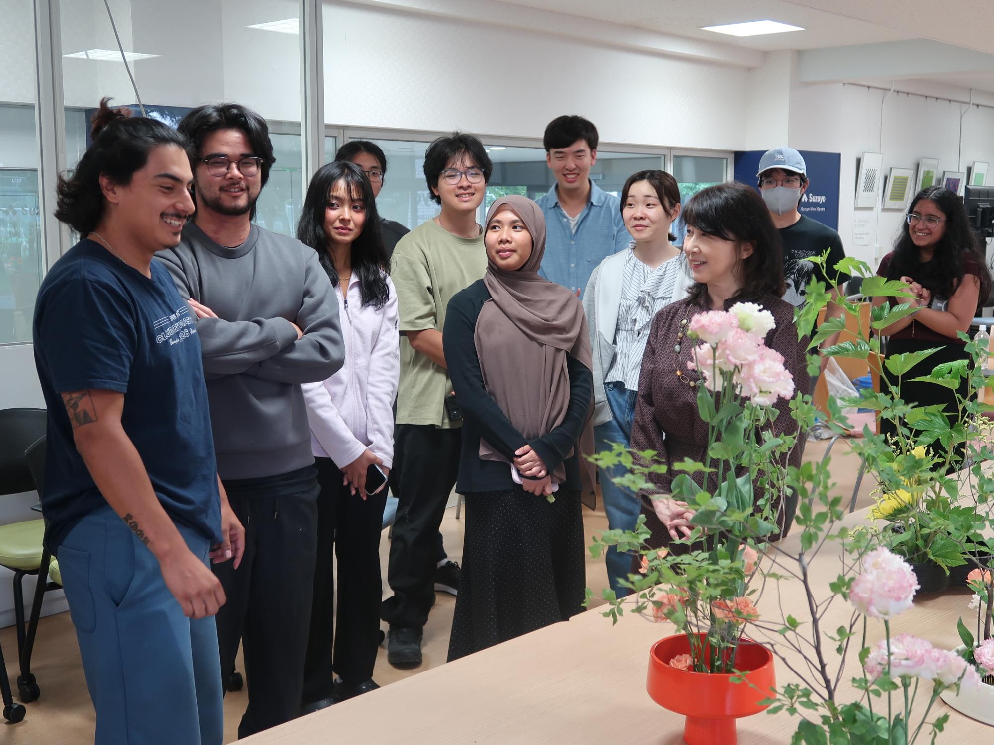 A group admires flowers arranged in pots