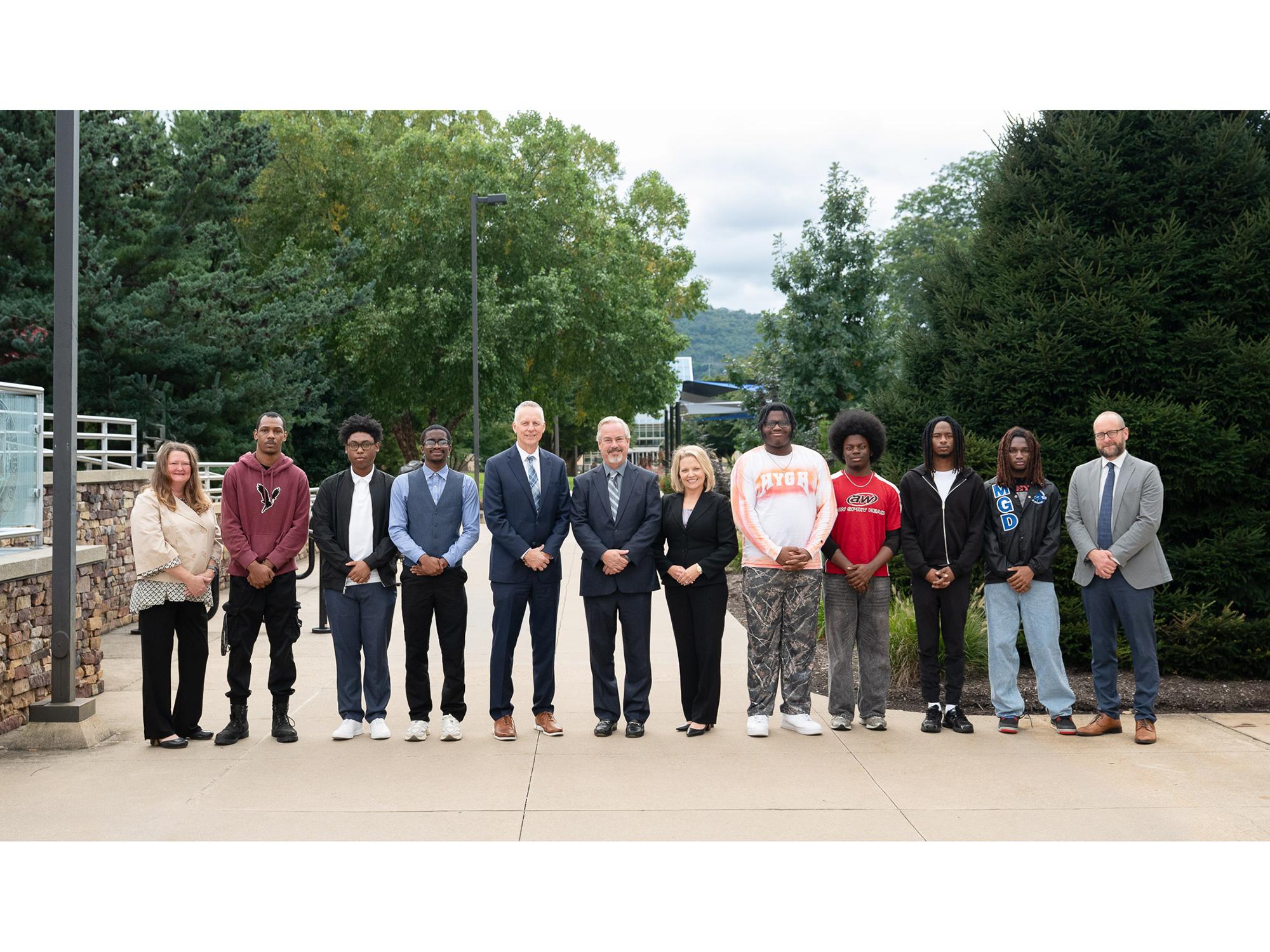 Brook Lenfest joins Penn College leaders and community members for a photo on the Penn College campus. The are lined up in a row.