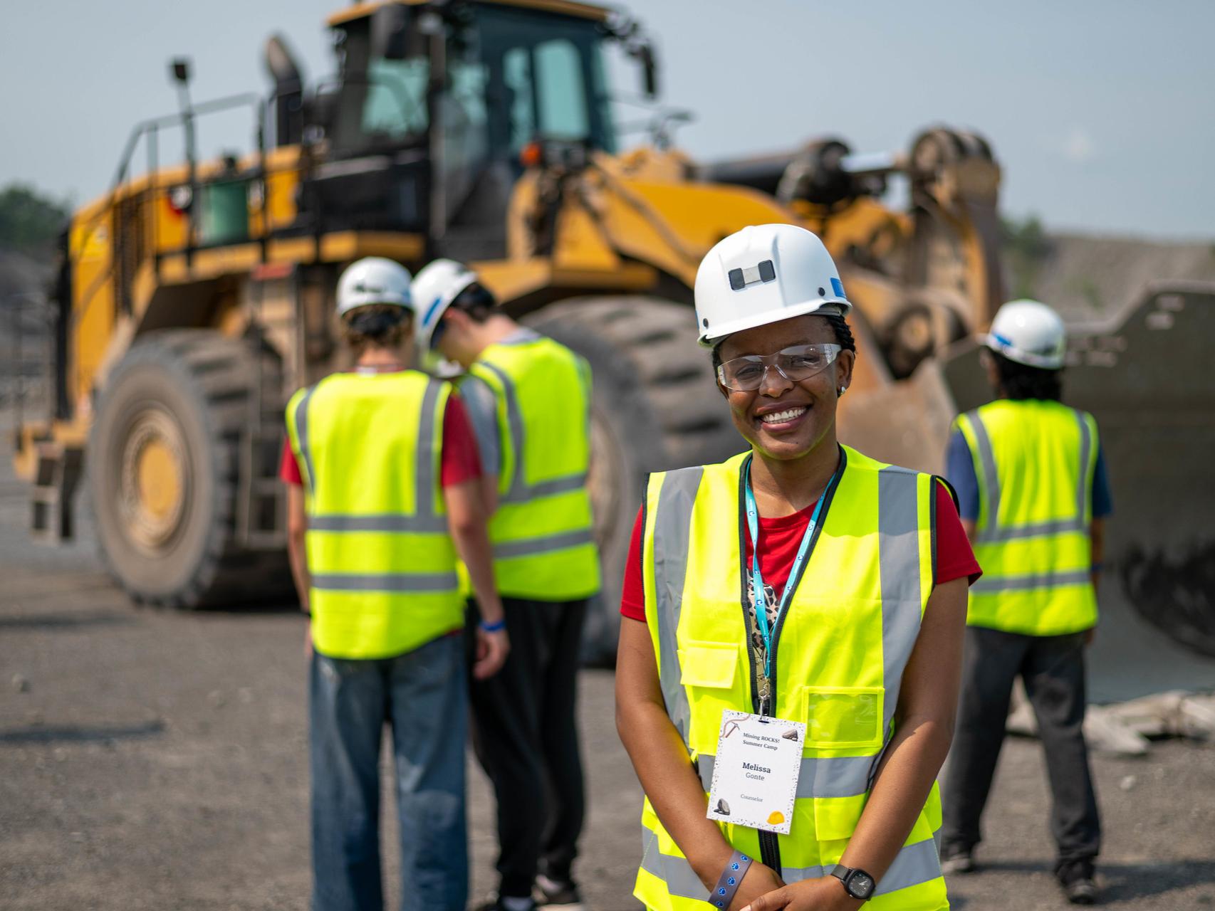 Woman in hard hat and construction gear at a mining site