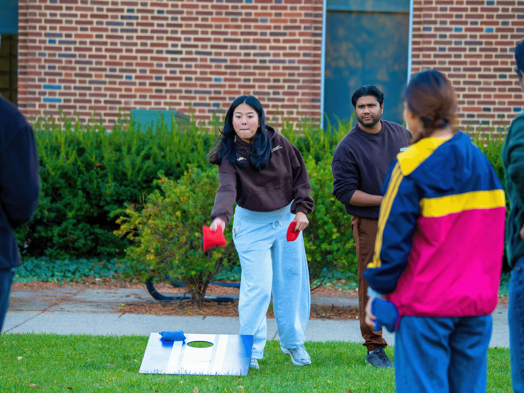 Graduate students bond over some friendly competition in a game of Cornhole.