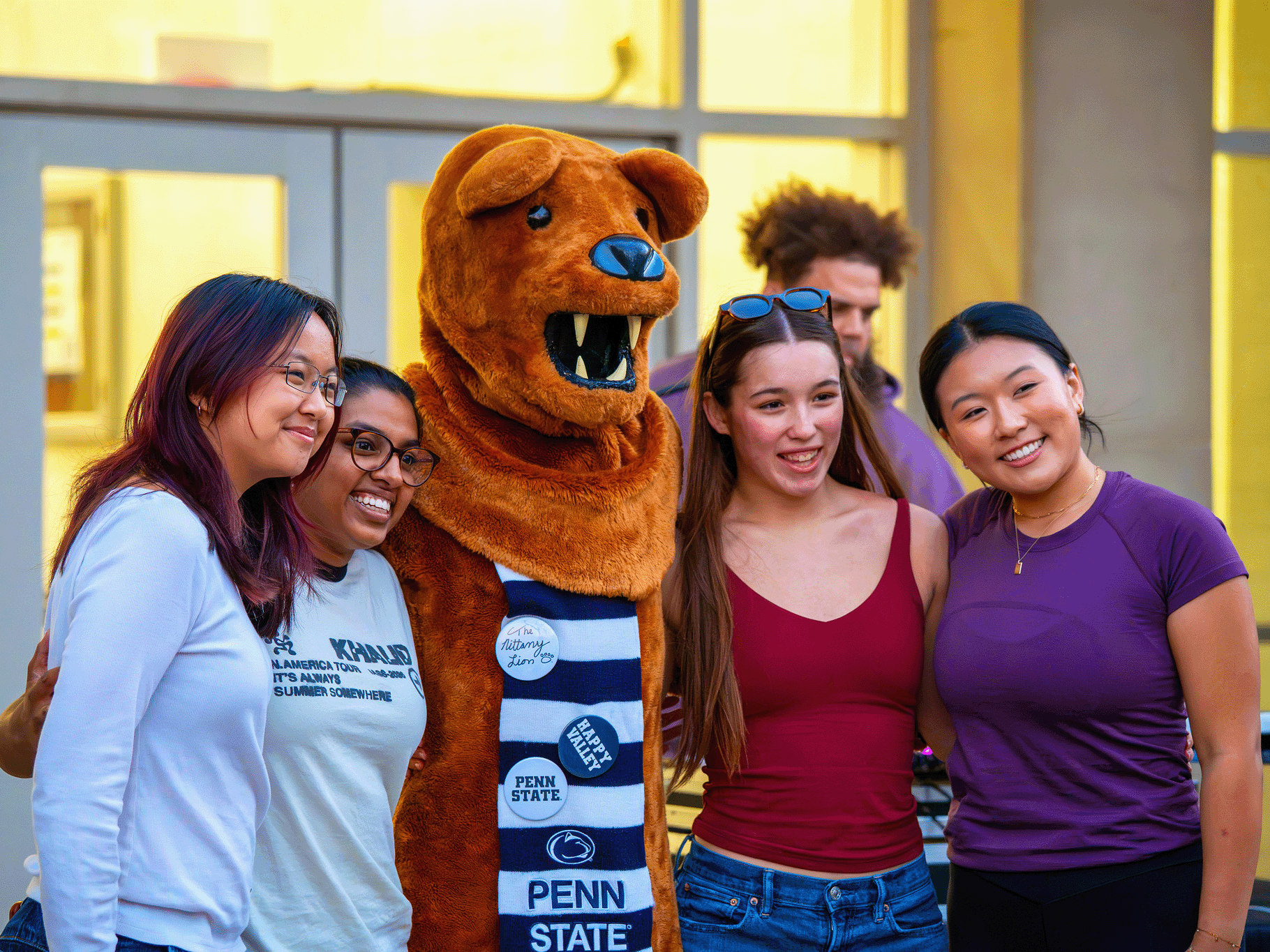 The Nittany Lion mascot poses with a group of graduate students outside the Kern Building. 