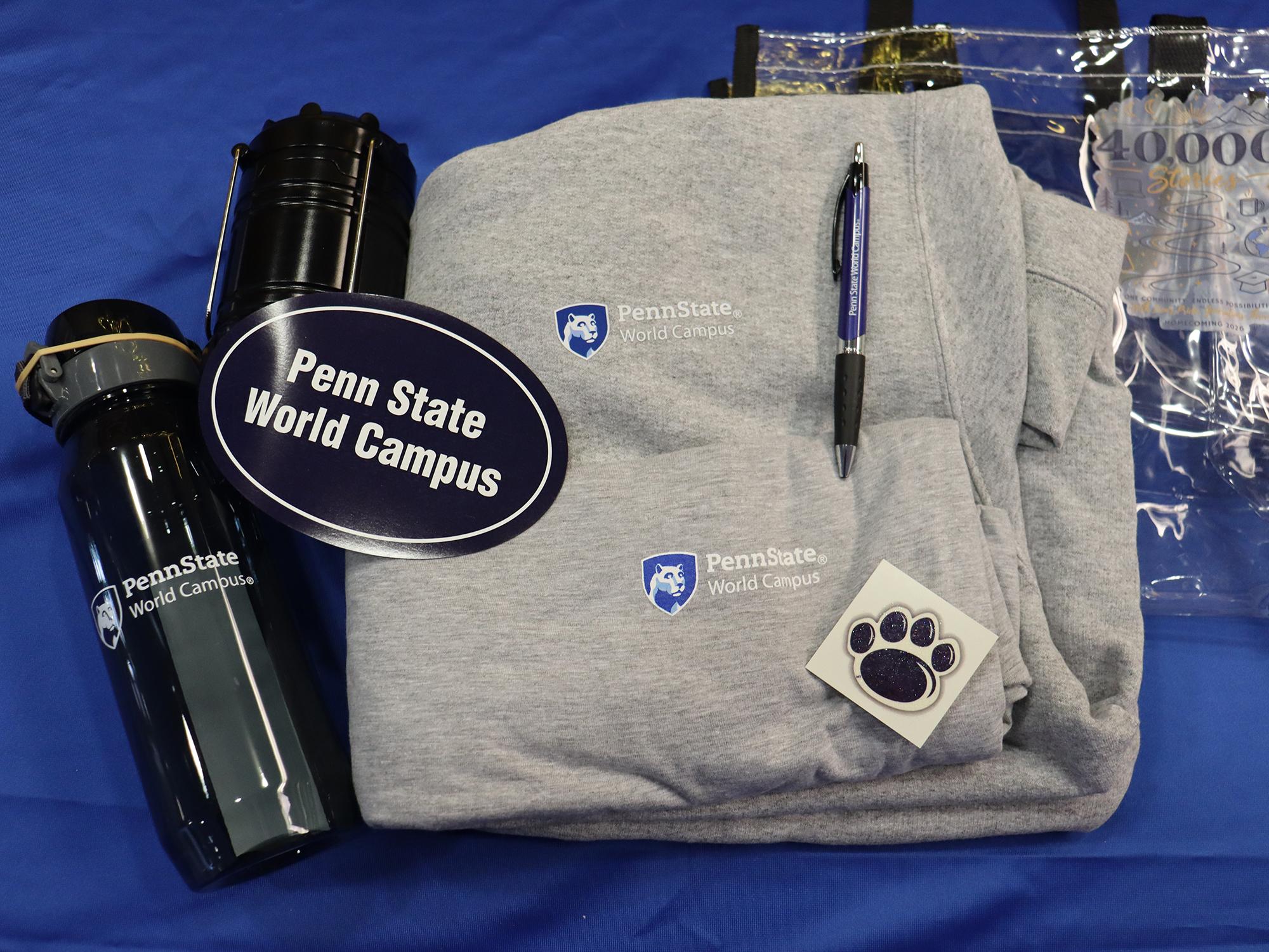 A variety of Penn State World Campus apparel displayed on a table.