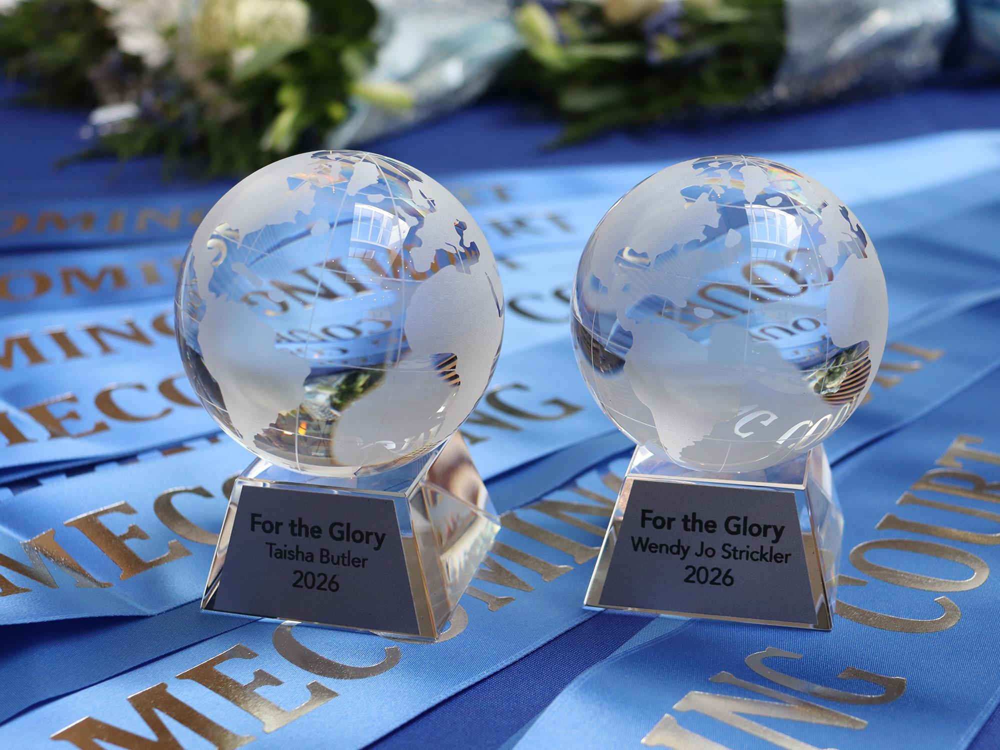 Crystal awards displayed on a blue table.