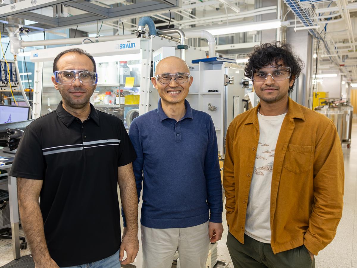 Three researchers pose in a lab