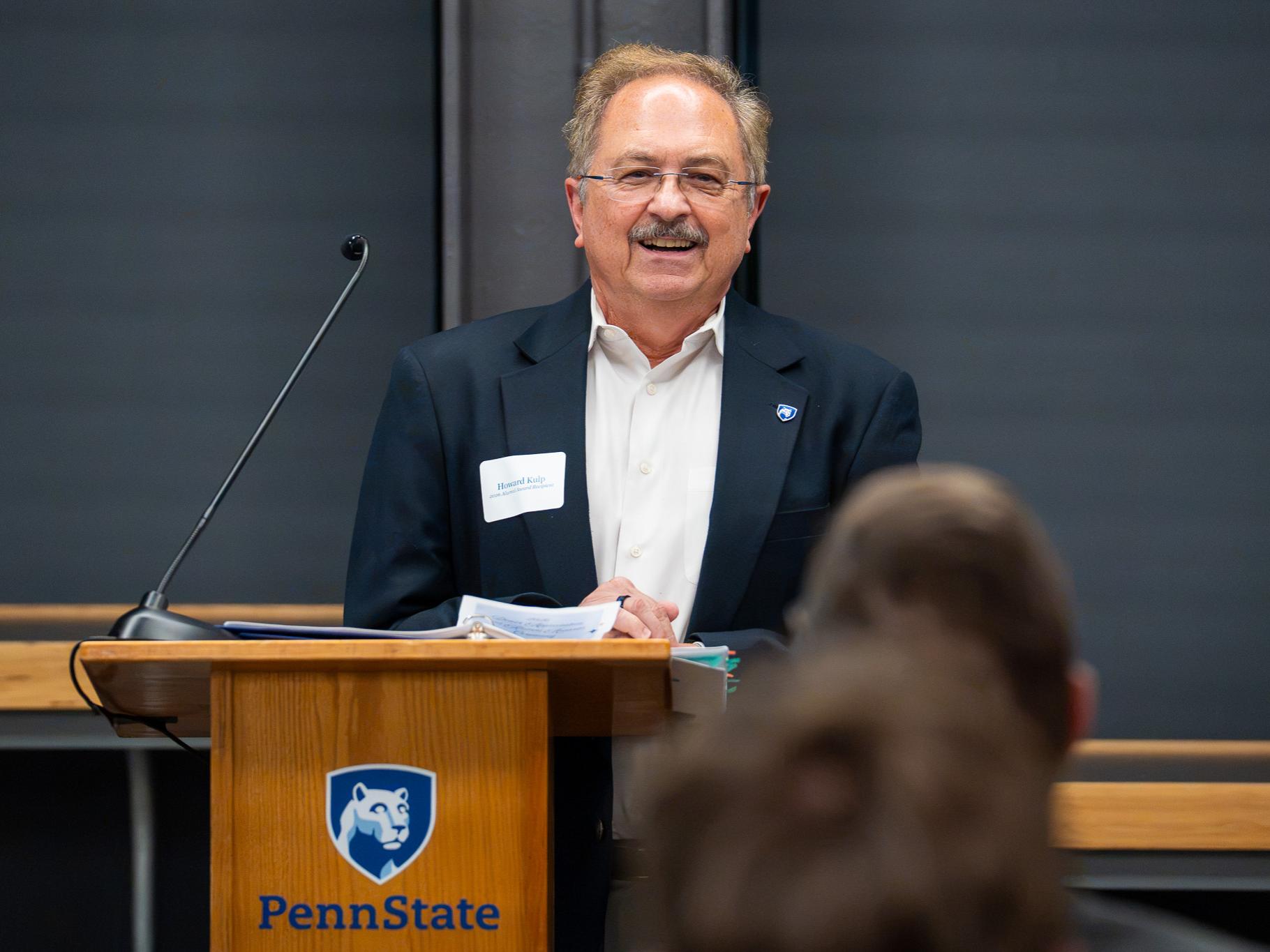man standing at a podium speaking