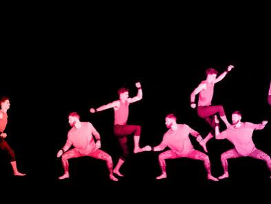A stereoscope image shows an acrobat running to the shoulders of his colleagues.