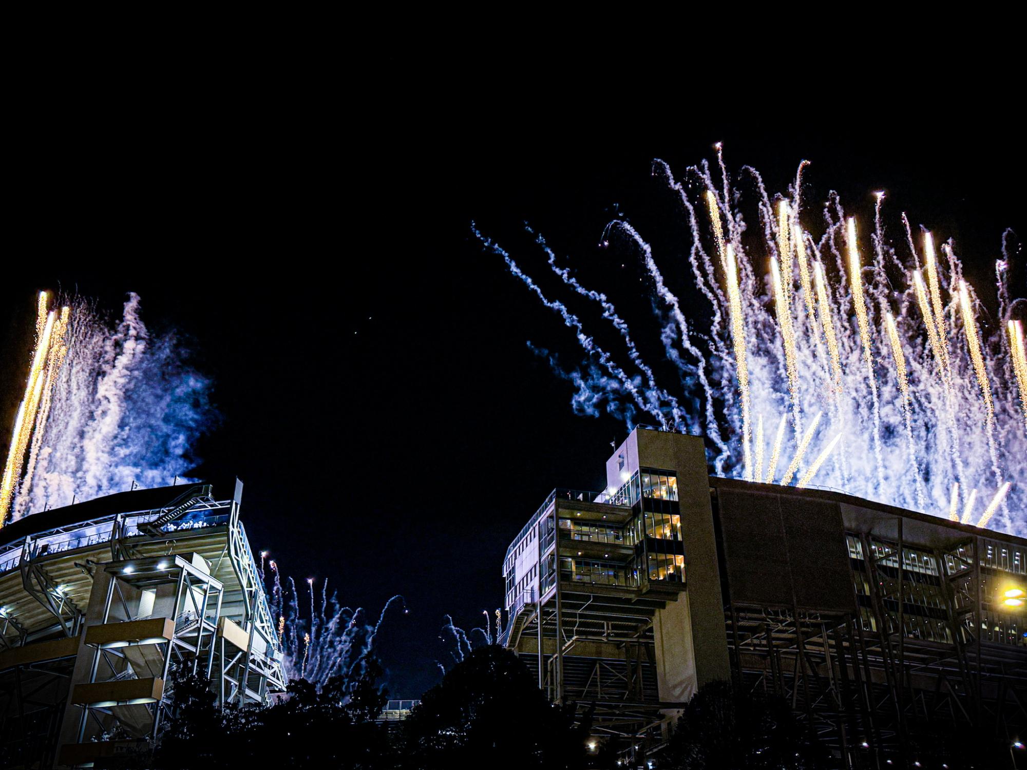 Blue and white fireworks shooting out atop Beaver Stadium