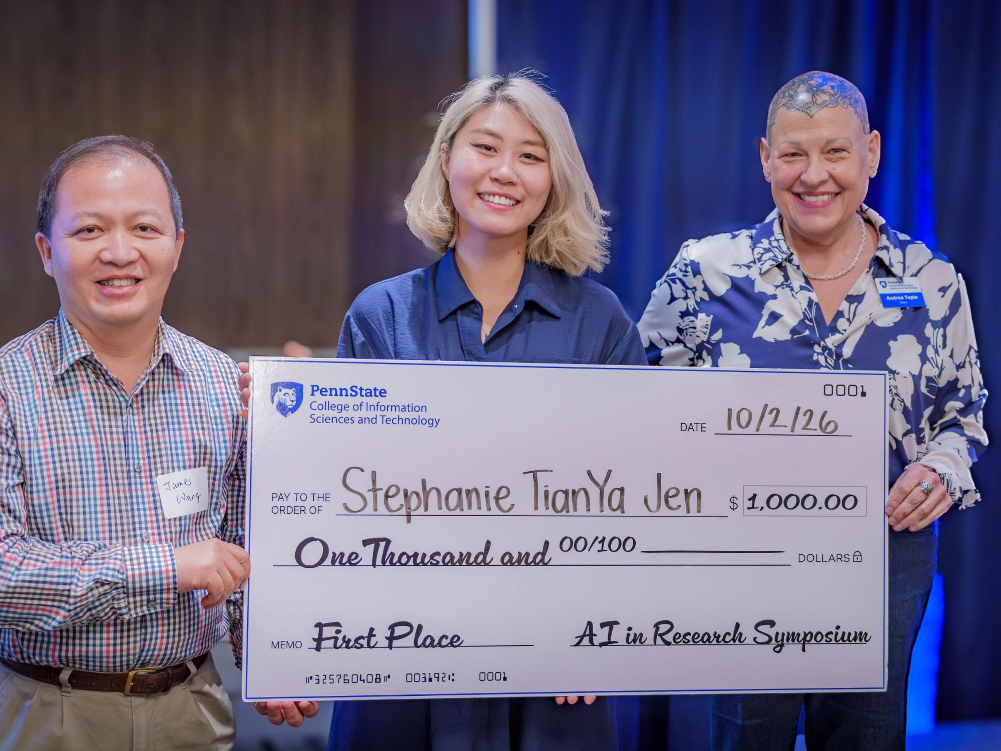 three smiling people hold giant thousand-dollar check