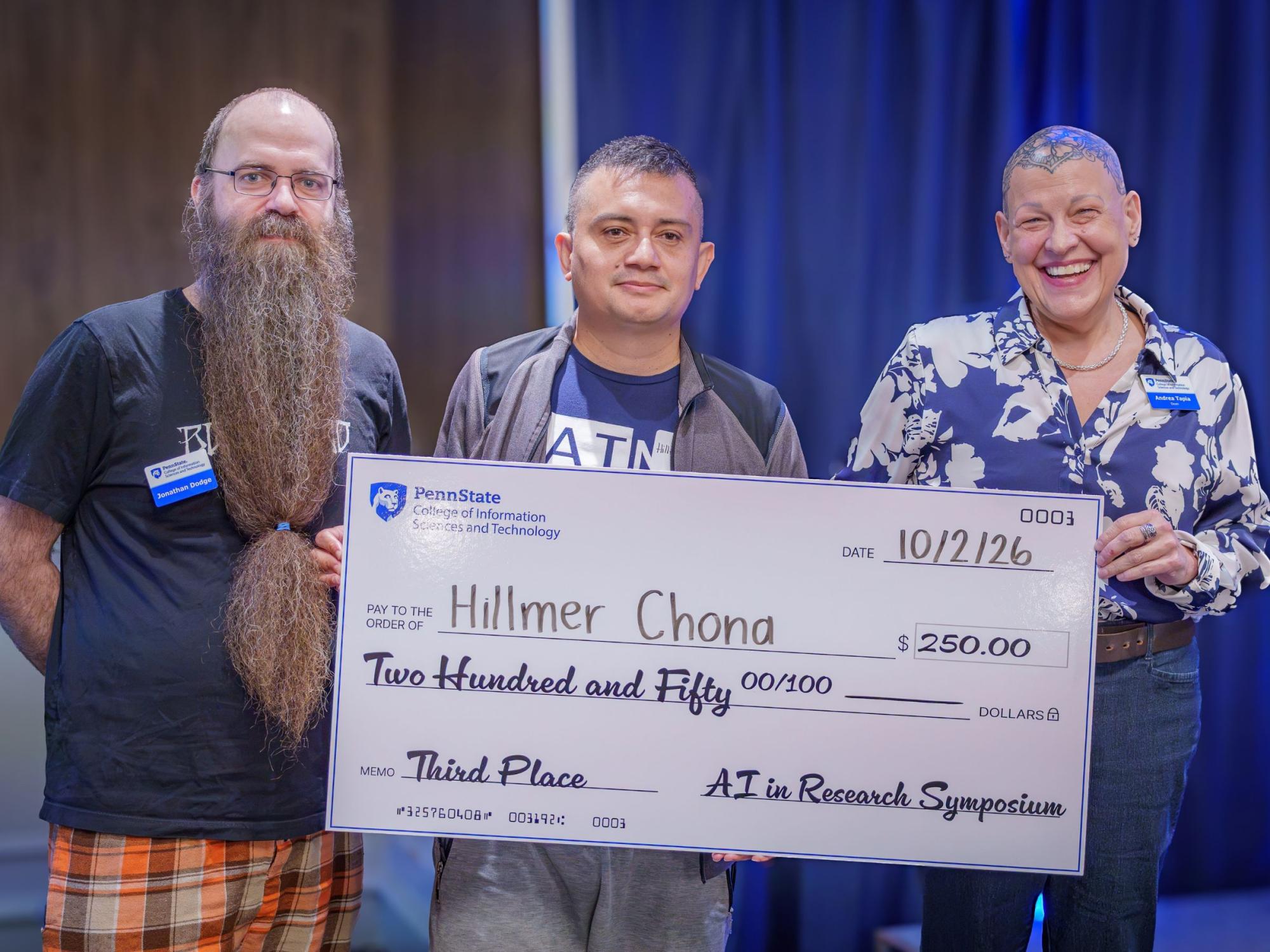 three smiling people holding giant check