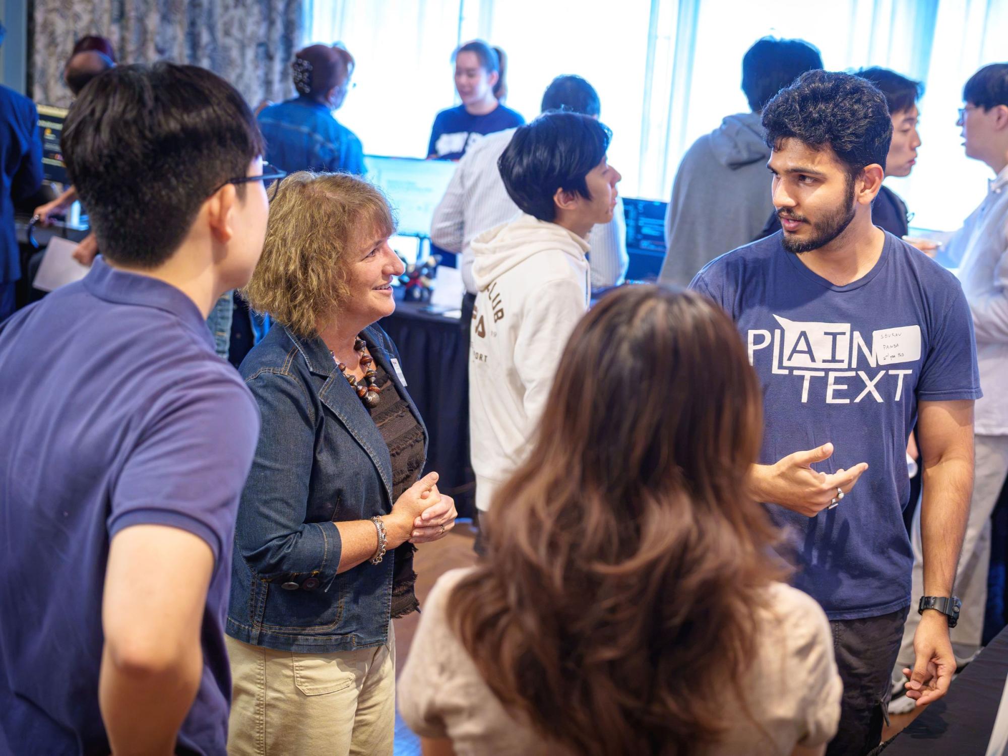 college student explains poster to small group of people